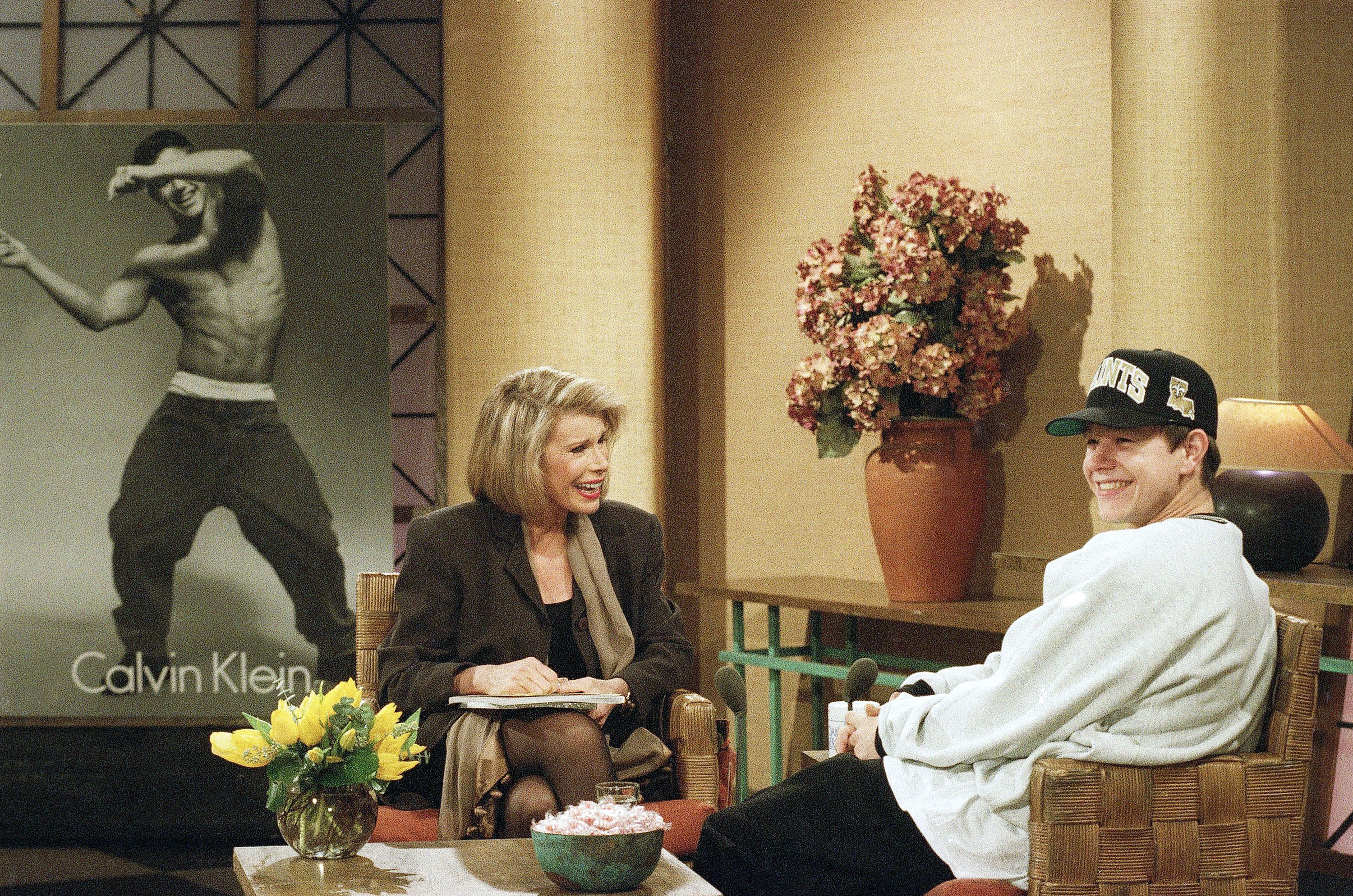 Rap star Marky Mark, right, reacts to a joke during his appearance on the Joan Rivers Show in New York Wednesday, Dec. 2, 1992. Mark unveiled one of the Calvin Klein underwear ads, background, that feature him wearing little but the product. (AP Photo/Bebeto Matthews) -- 19wahlside