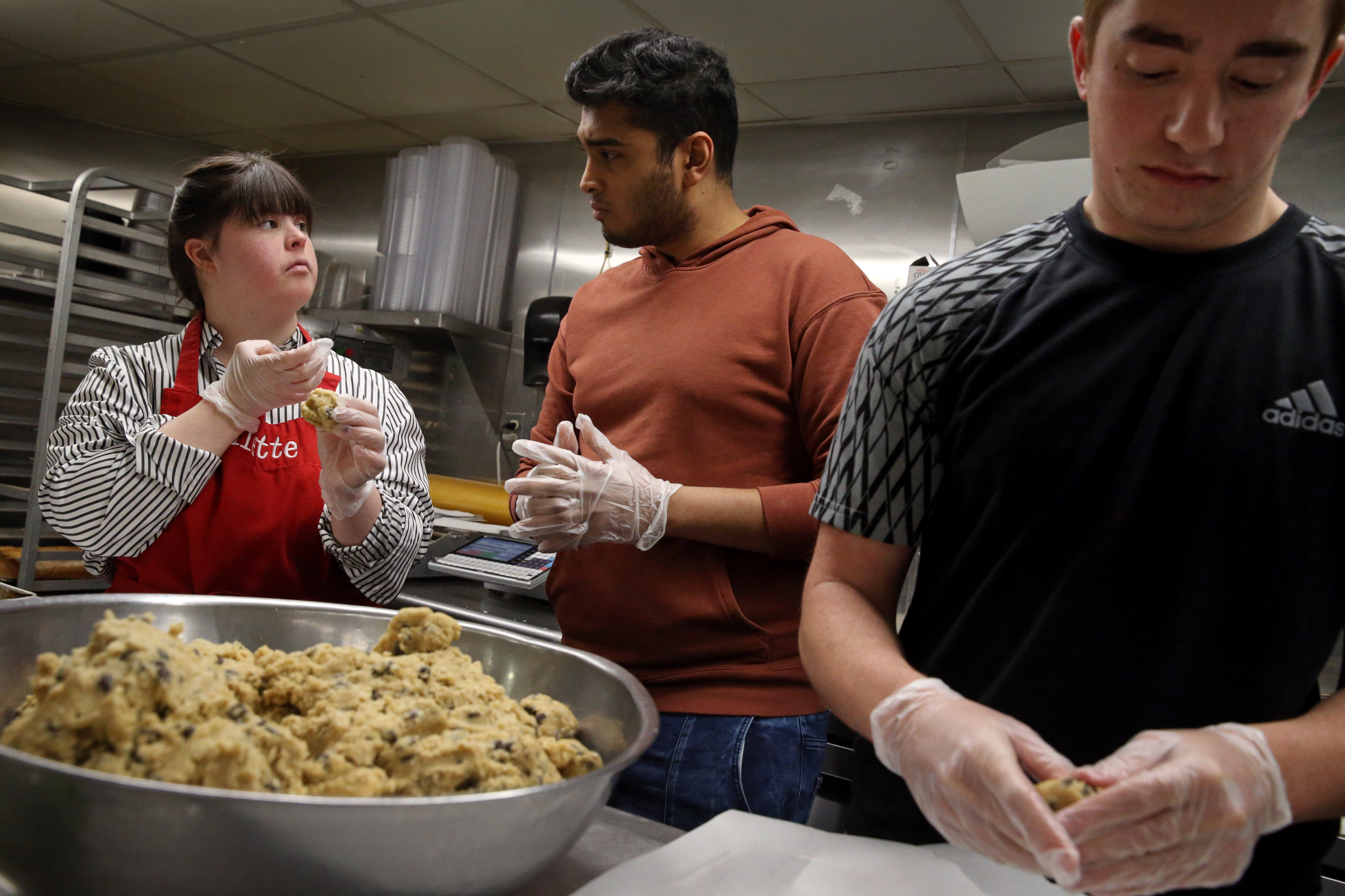 Divitto instructed workers Ronak Maheshwari, center, and Nathan Rosenstein while they made her cookie recipe.
