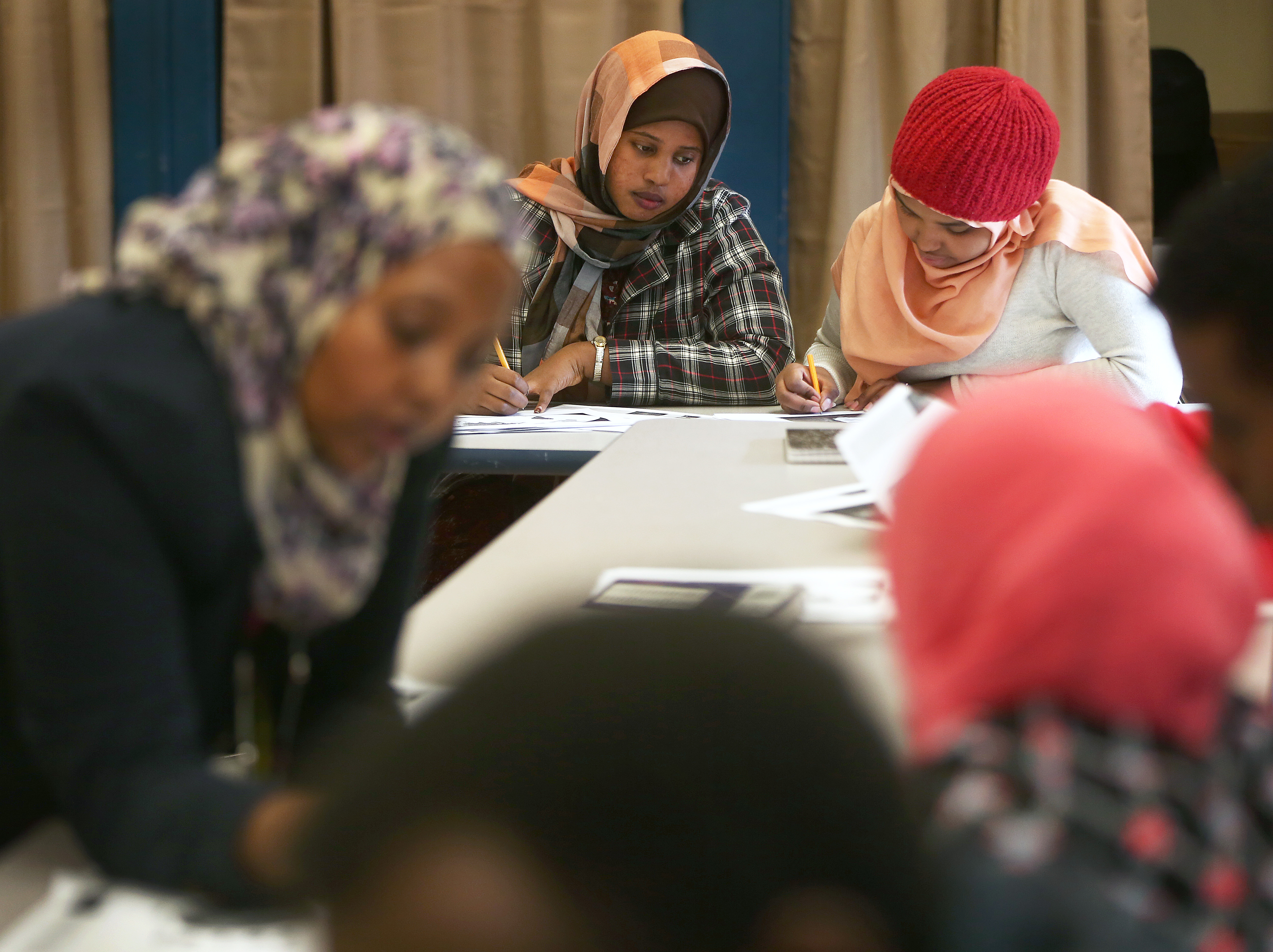 Teacher Mona Farah (left) worked with students at Boston International Newcomers Academy, a district high school that welcomes immigrants who arrive throughout the school year.