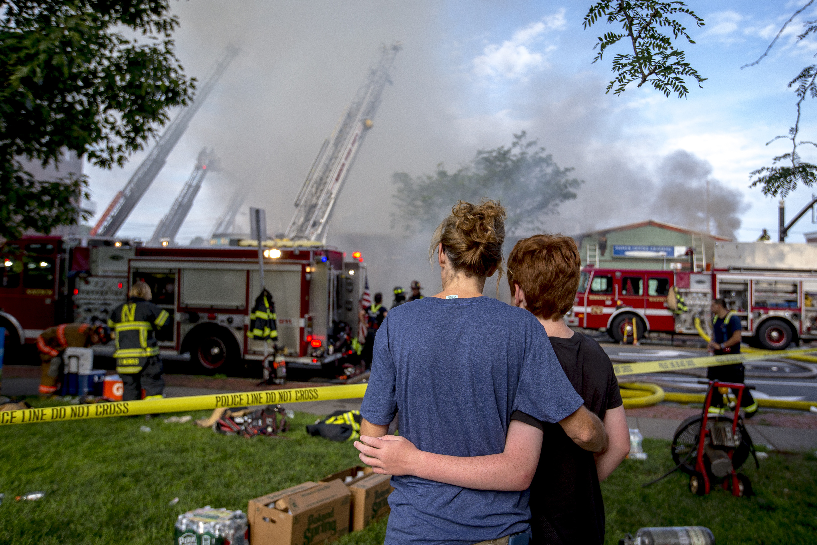 Suna Bayrakal of Natick (left) embraced her son, Kadrik Young, 11, as they watched firefighters at work.