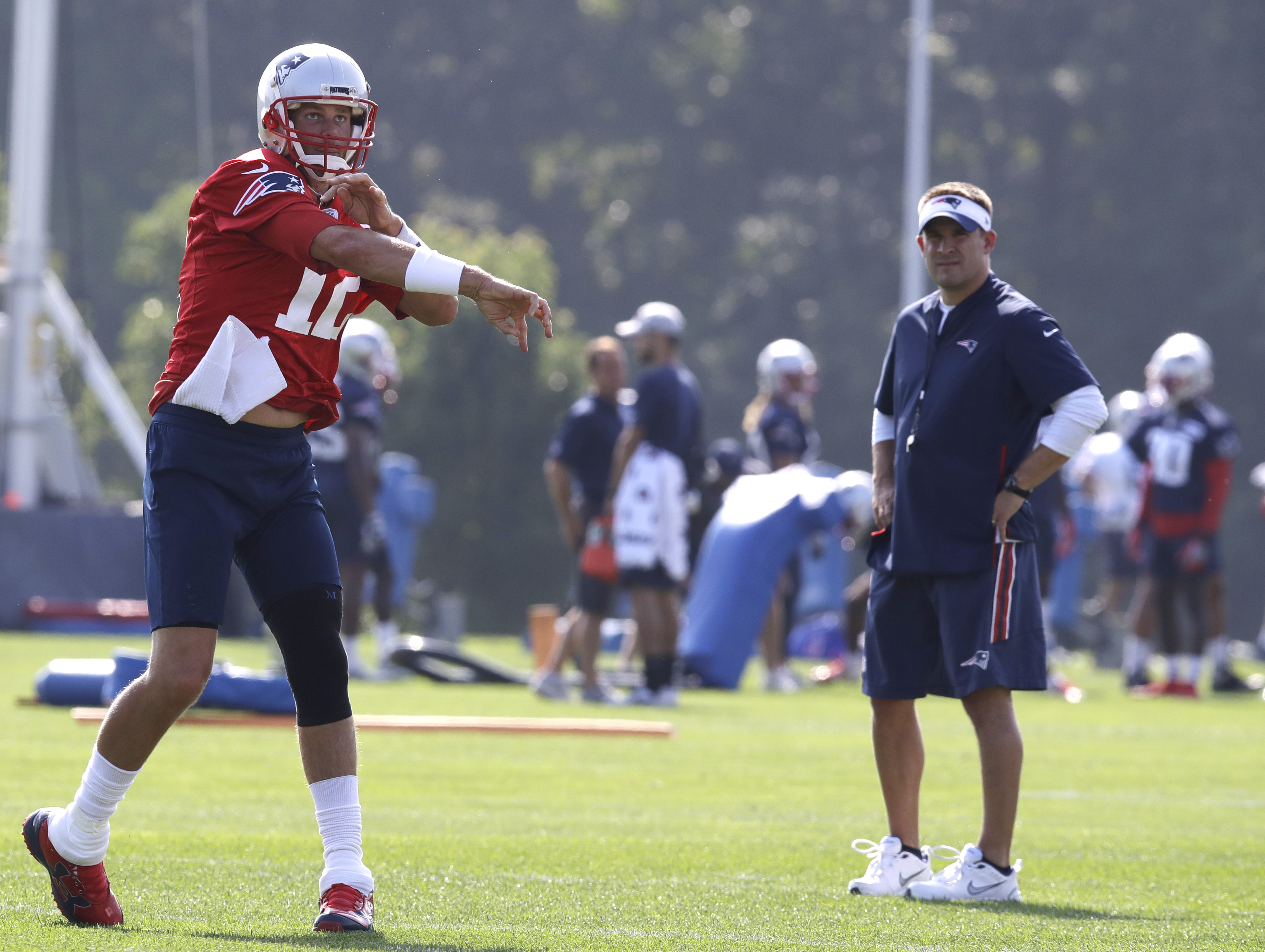 McDaniels with Patriots quarterback Tom Brady during training camp in July. McDaniels grew up watching how his father, a noted high school football coach, worked.