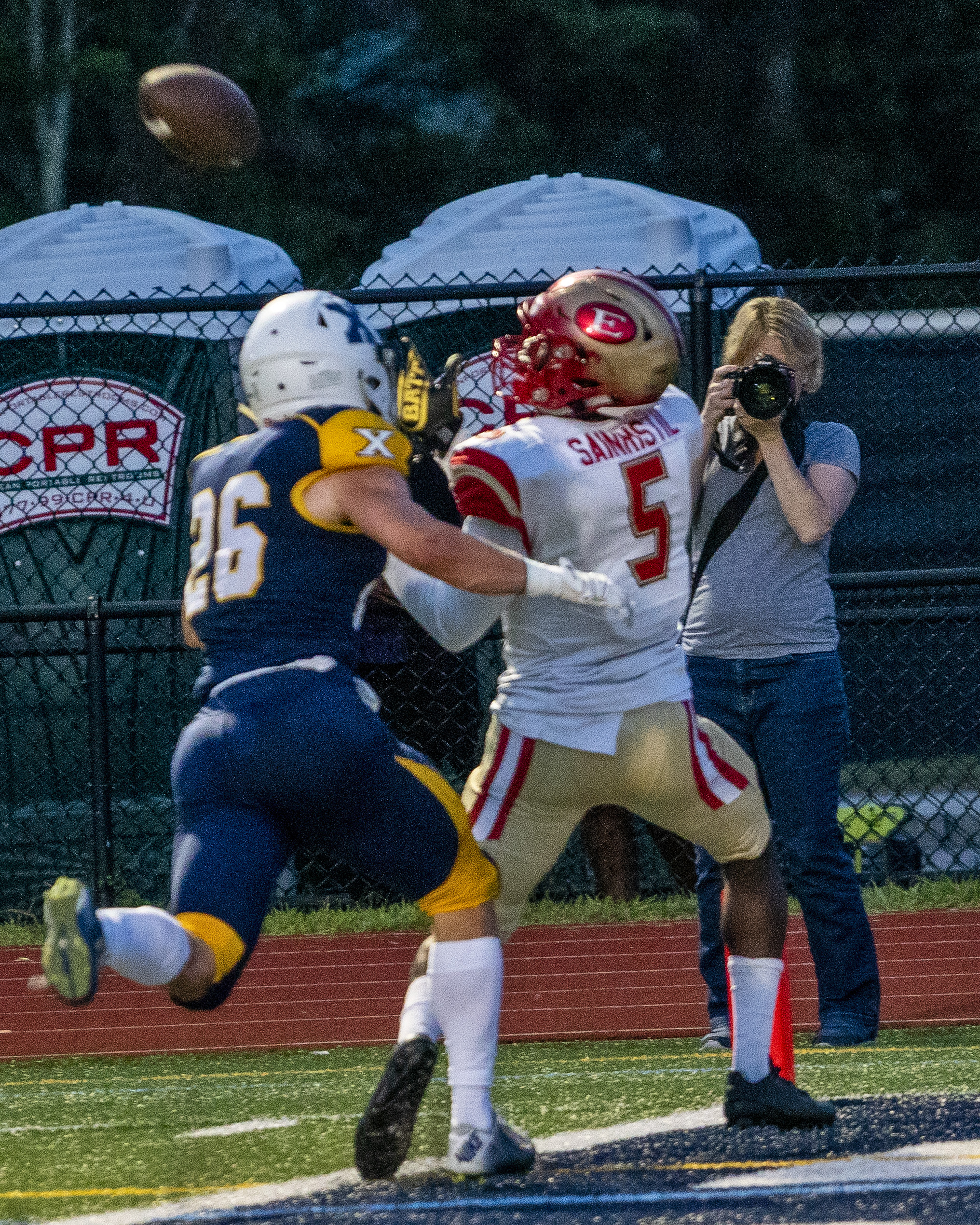 Everett’s Mike Sainristil (5) watches the ball head for him over the coverage of Xaverian's Cooper Deveau (26) in Westwood Friday night.
