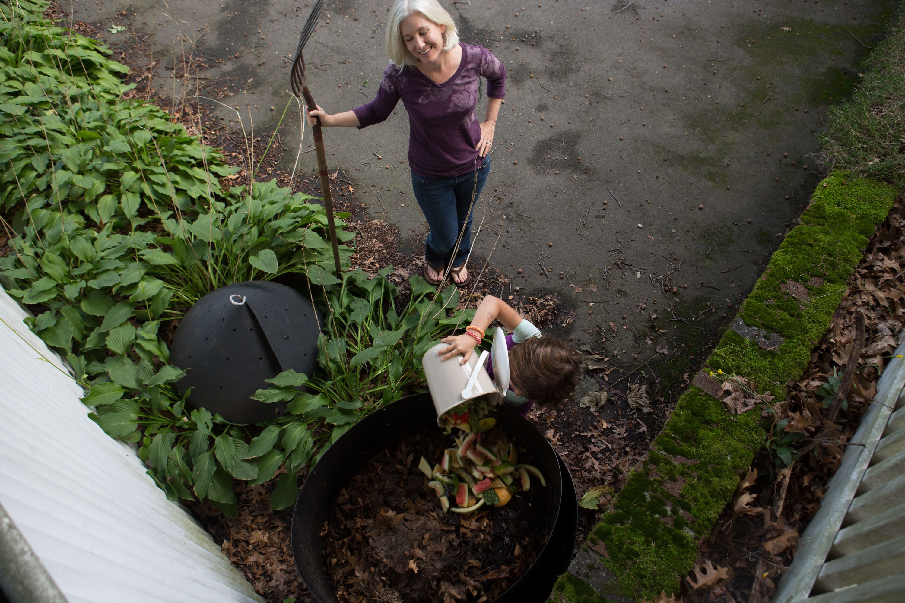 Sarah Birkeland (rear) and her daughter, Abby Edelstein, mixed waste food into their backyard composter.