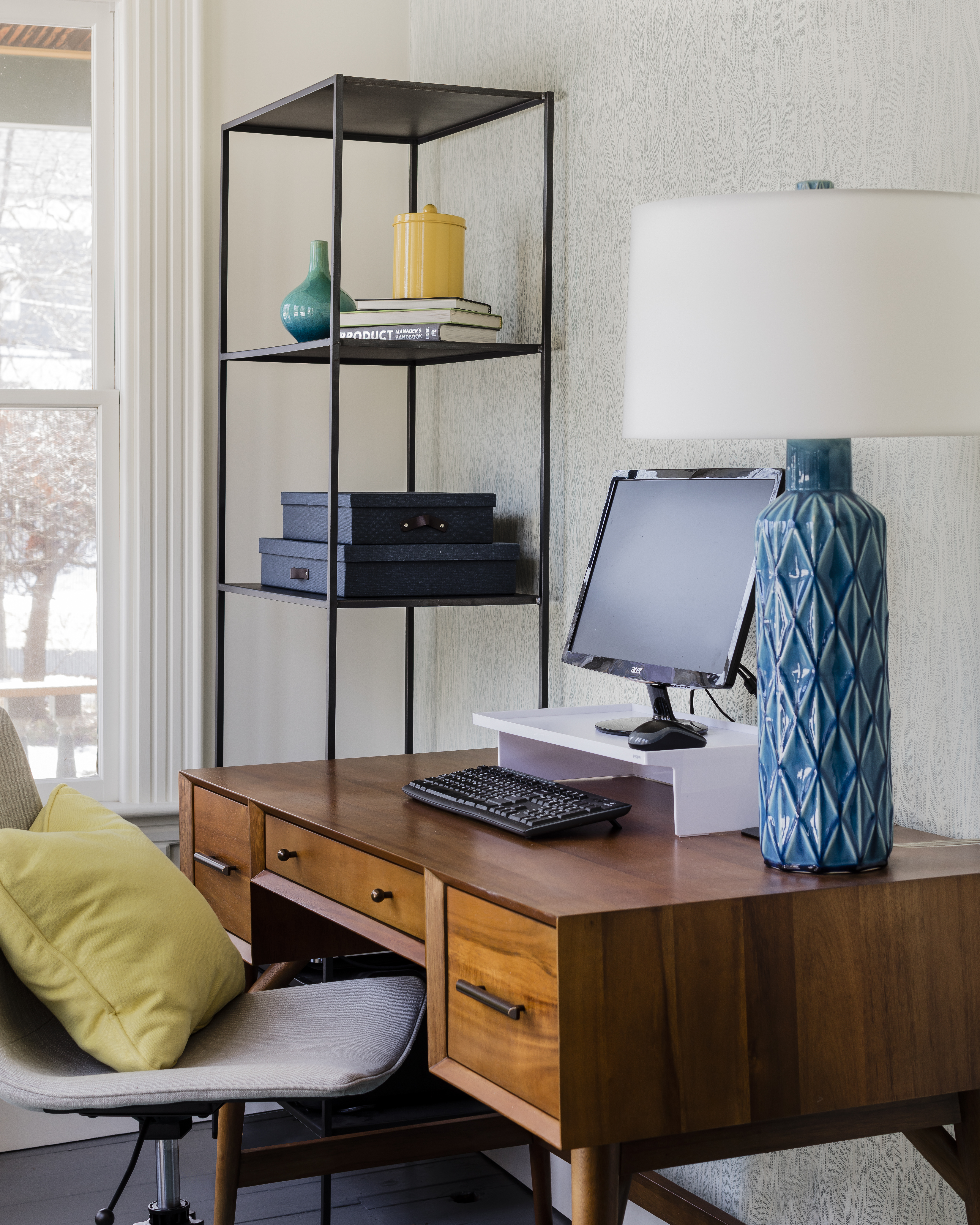 In the sunroom-turned-office (below), which is visible from the dining room, the teal-and-yellow color scheme carries through. The desk is from West Elm, and the lamp is by Arteriors Home.