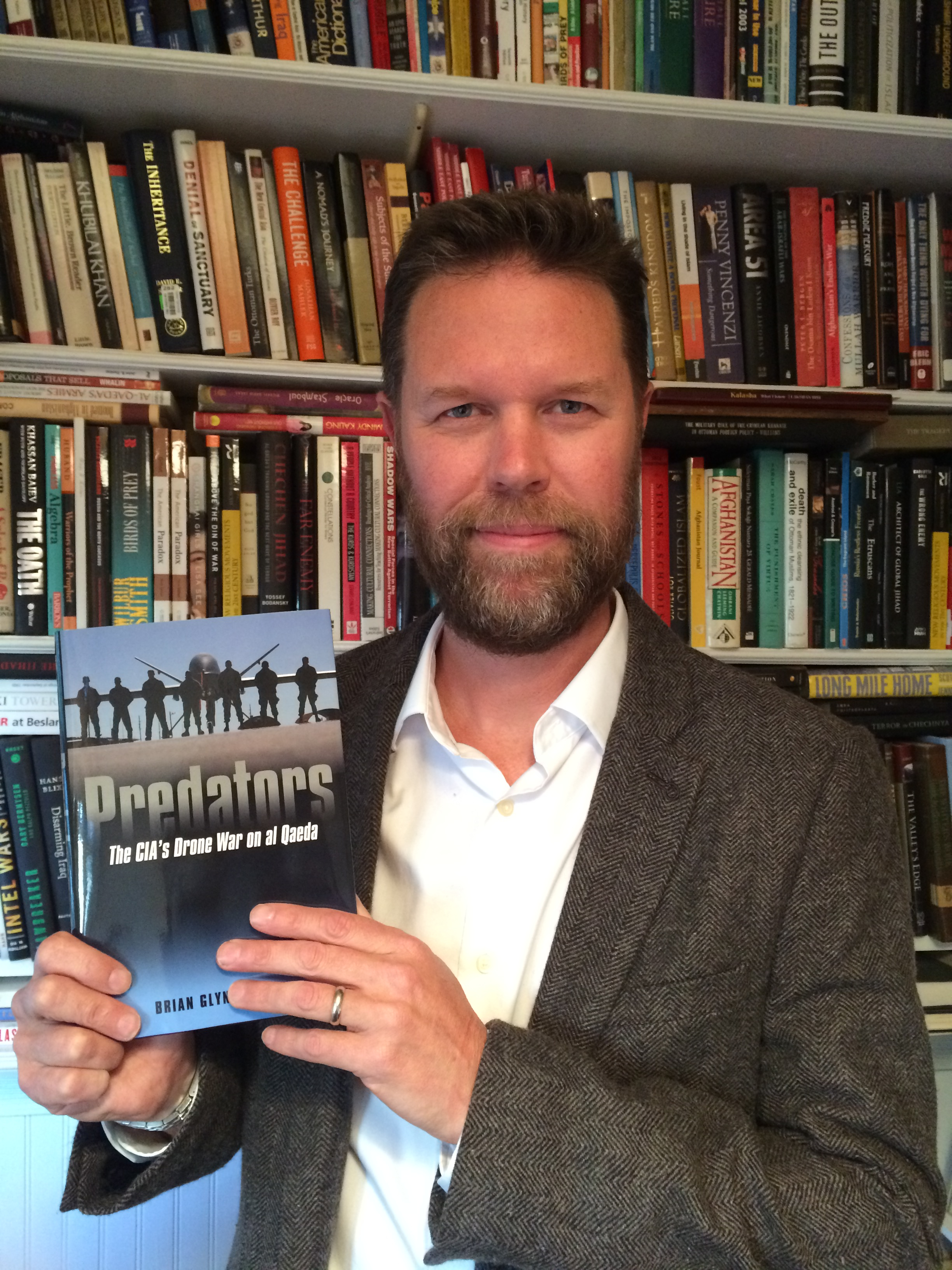 UMass Dartmouth professor Brian Glyn Williams with his book "Predators: The CIA's Drone War on Al Qaeda."