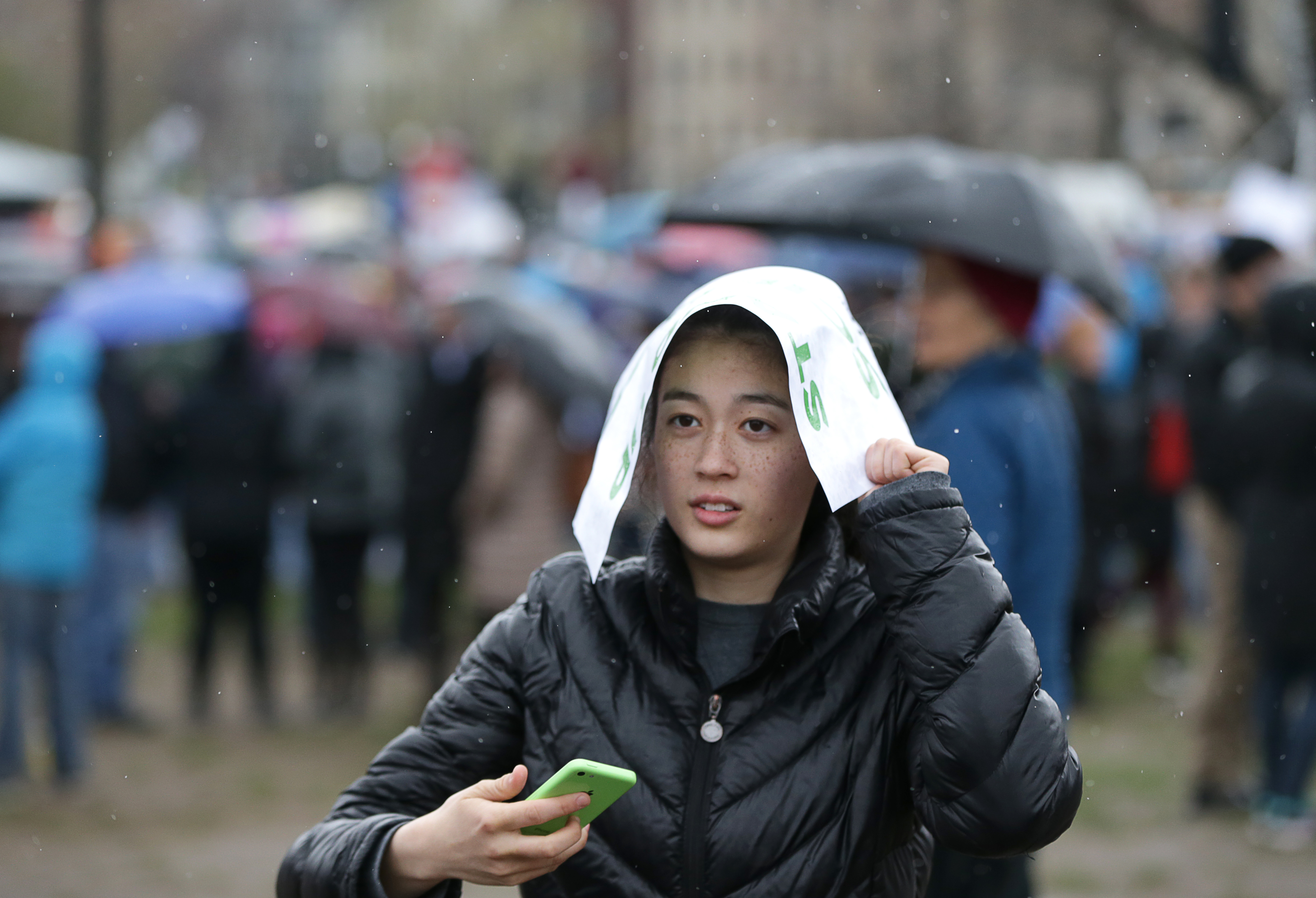 Some of those without umbrellas repurposed signs for protection from the rain.