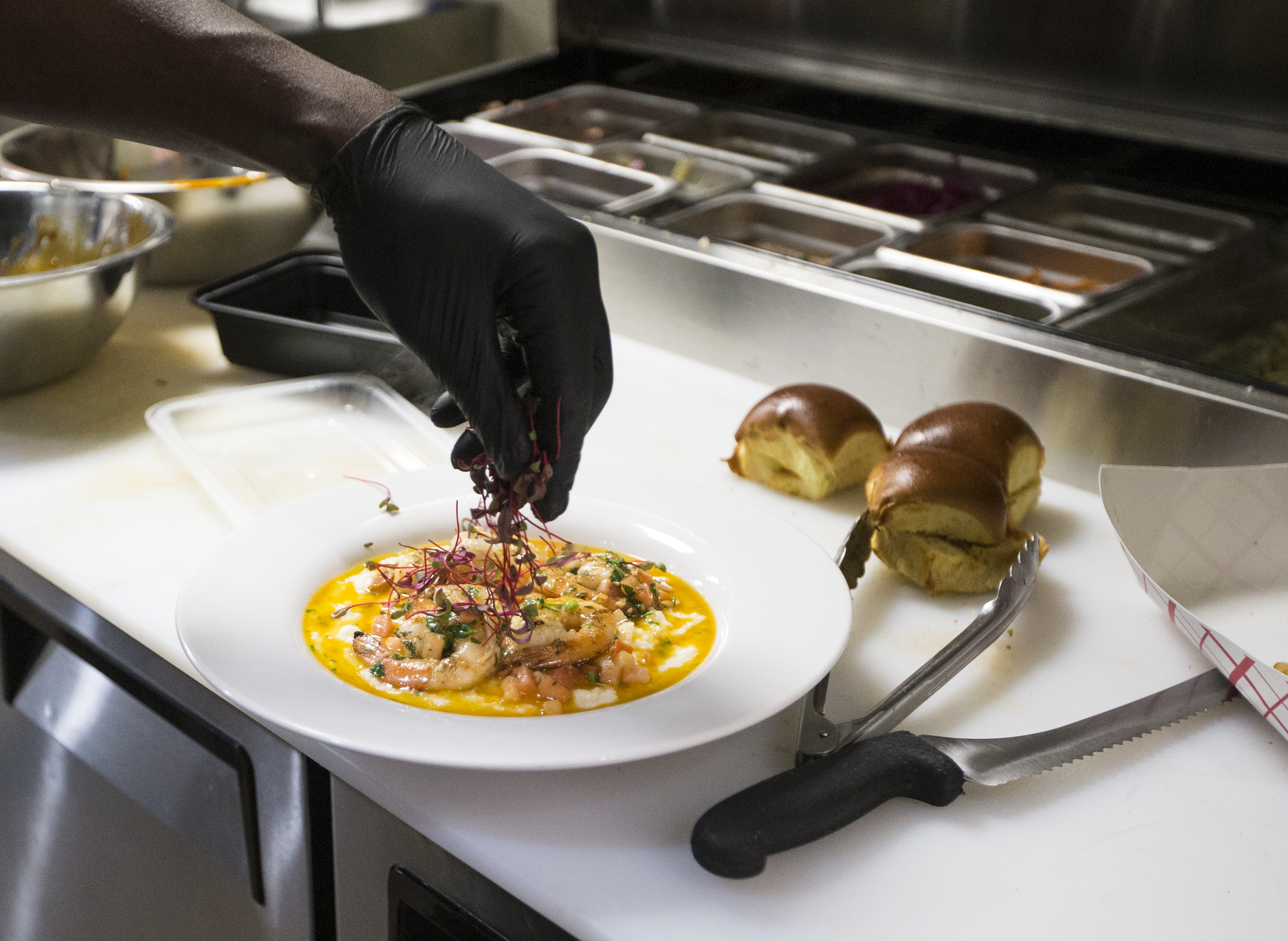 Anthony Caldwell, owner and executive chef at 50Kitchen, garnished a shrimp and grits dish on Friday.