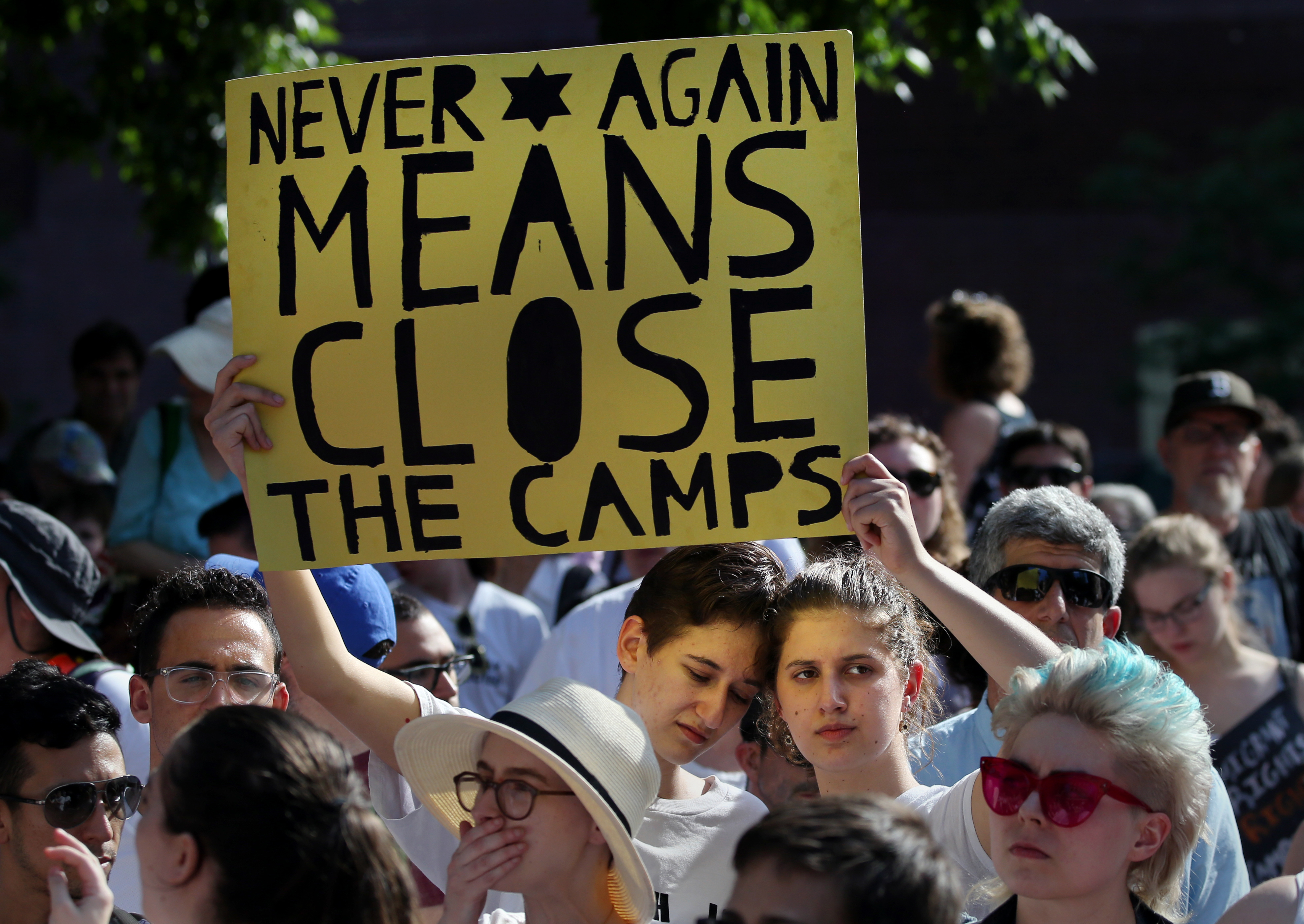 LilyFish Gomberg, left, and her sister, Maya Gomberg listened to a speaker during a protest of ICE border detention facilities, at the New England Holocaust Memorial in Boston on Tuesday.