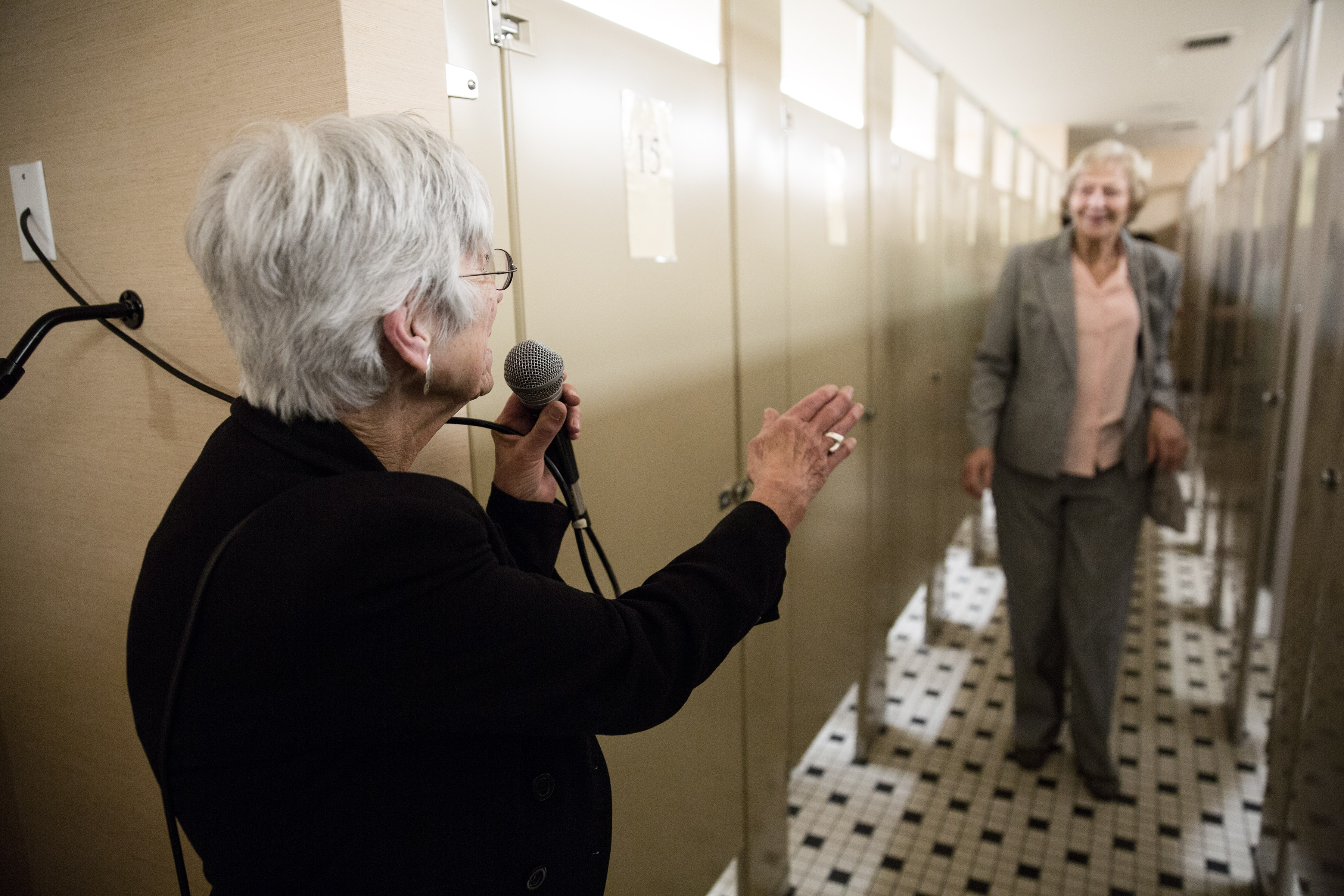 Paula Brennan, using a microphone to call out the numbers of available stalls, provides direction to female patrons at the Boston Opera House.