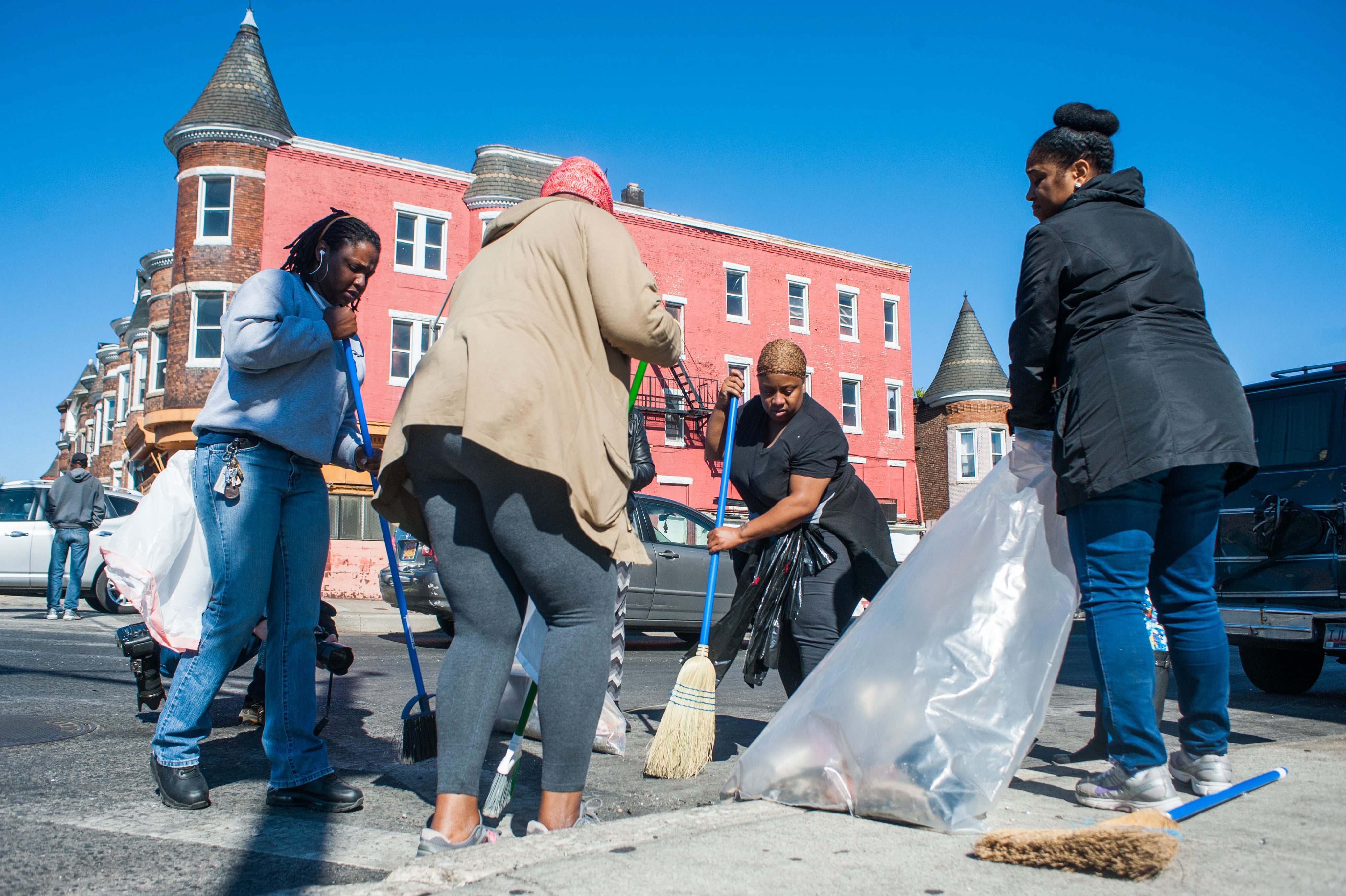 Volunteers cleaned up trash and shattered glass in front of a looted business at the intersection of North Avenue and Fulton Avenue.