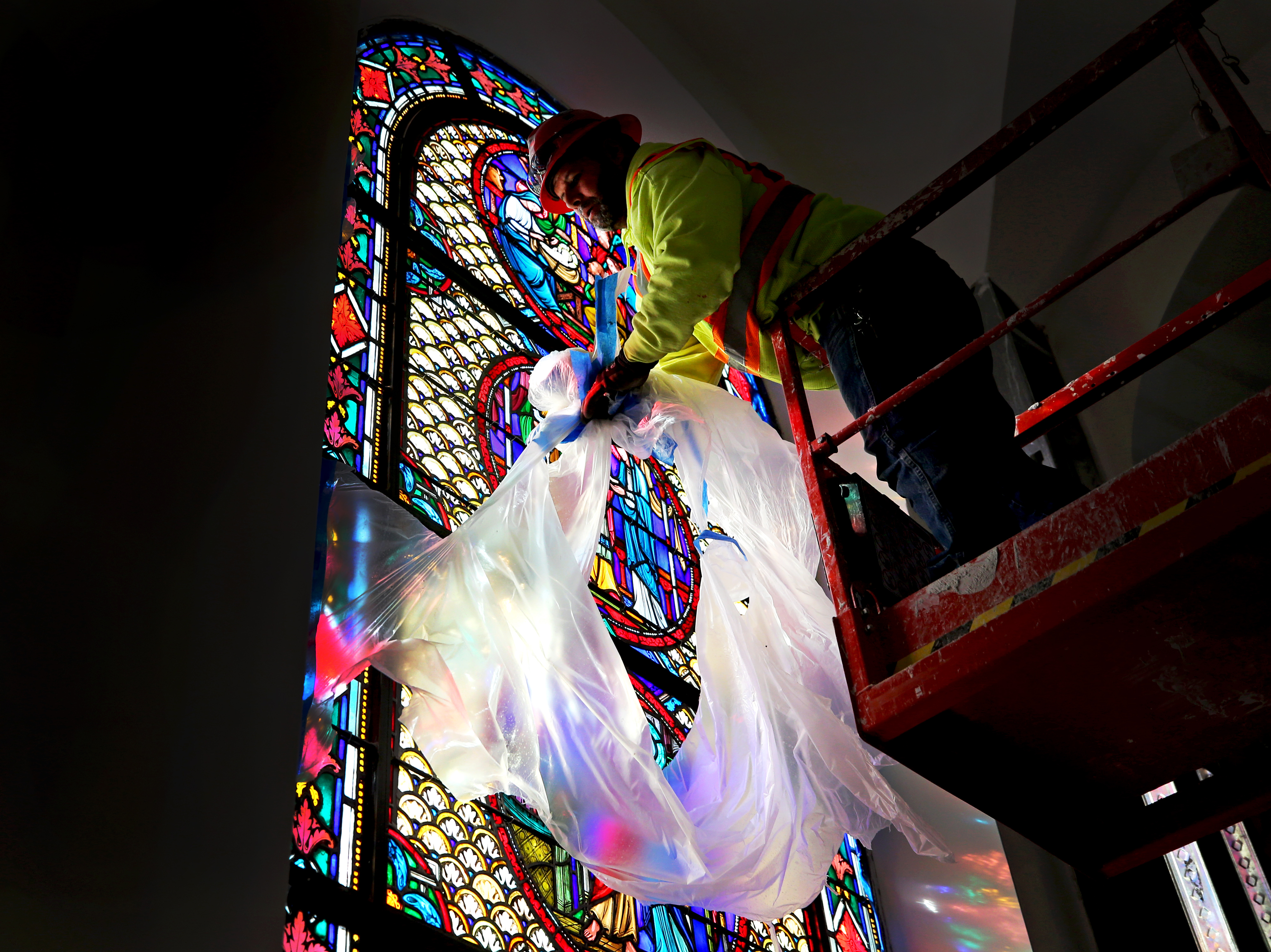 Mohmed El Bhawan removed the protective plastic covering from the restored stained glass windows.