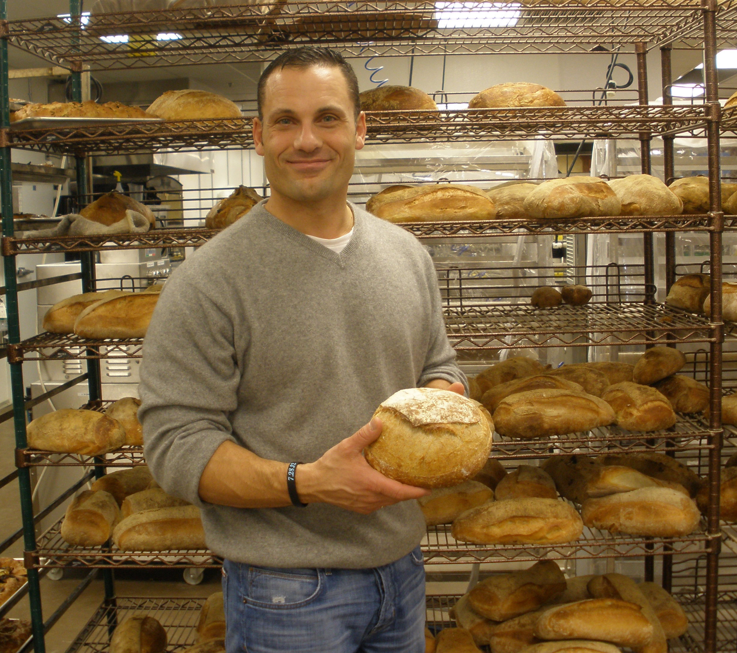 16tuscan - Joe Faro, owner of Tuscan Market and Tuscan Kitchen restaurant in Salem, NH, with some of the dayâs breads. (Lisa Zwirn)