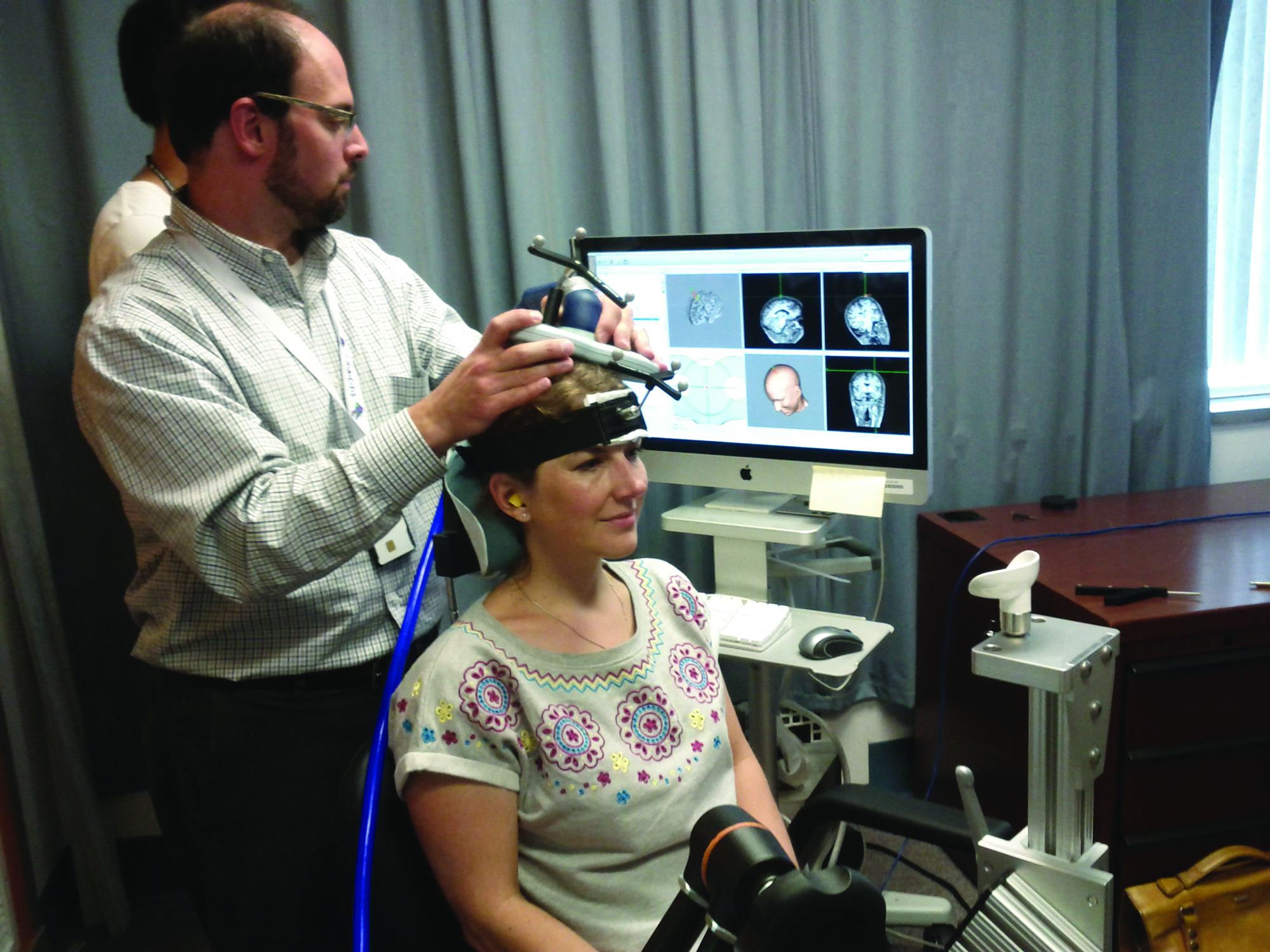 Researcher Mike Esterman applies transcranial magnetic stimulation to Caroline Williams’s brain at the Boston Attention and Learning Lab at the VA Medical Center.