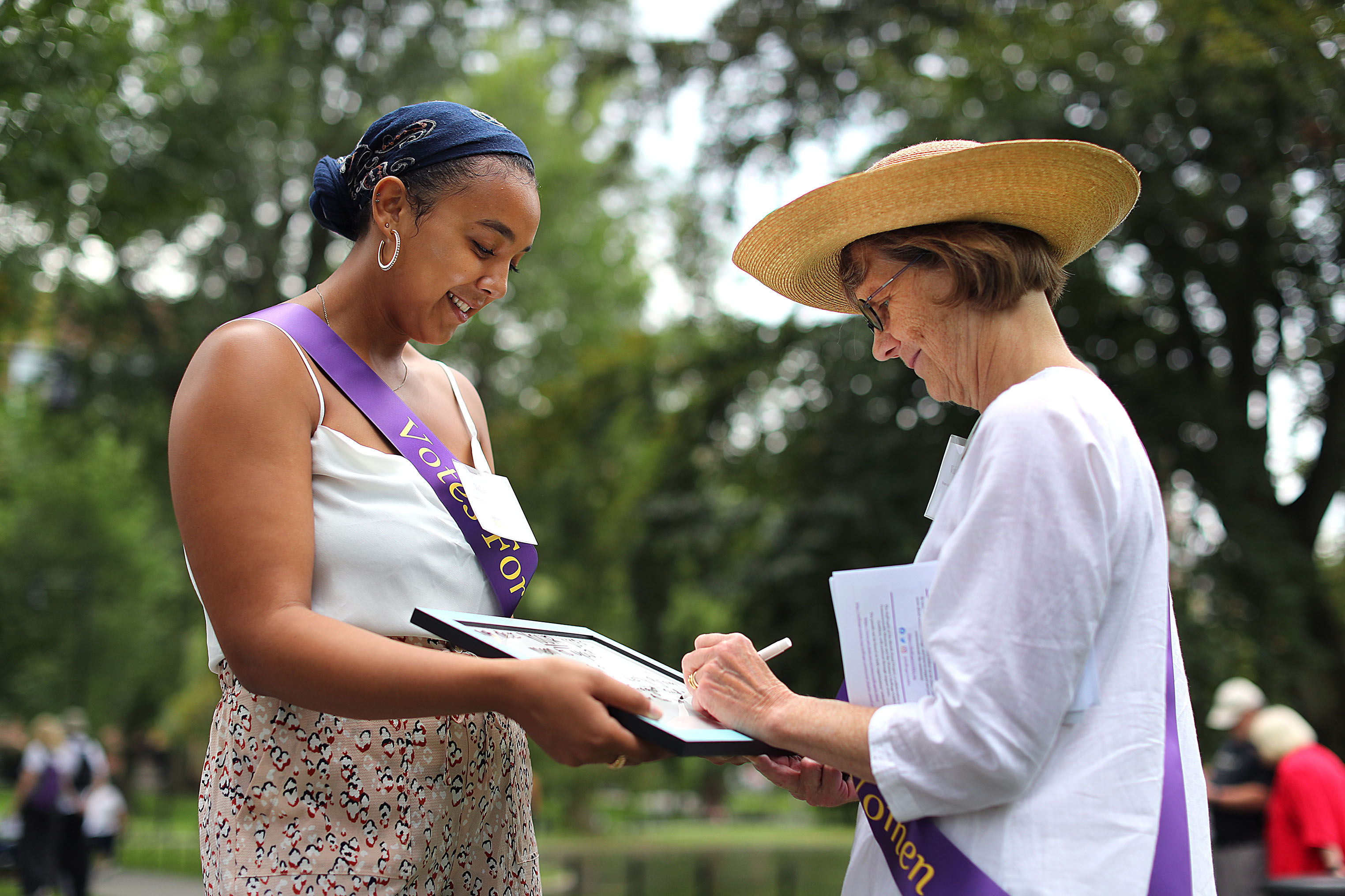 Bria Gambrell (left) held a whiteboard on which Pam Swing wrote her answer to: What does your vote mean to you?
