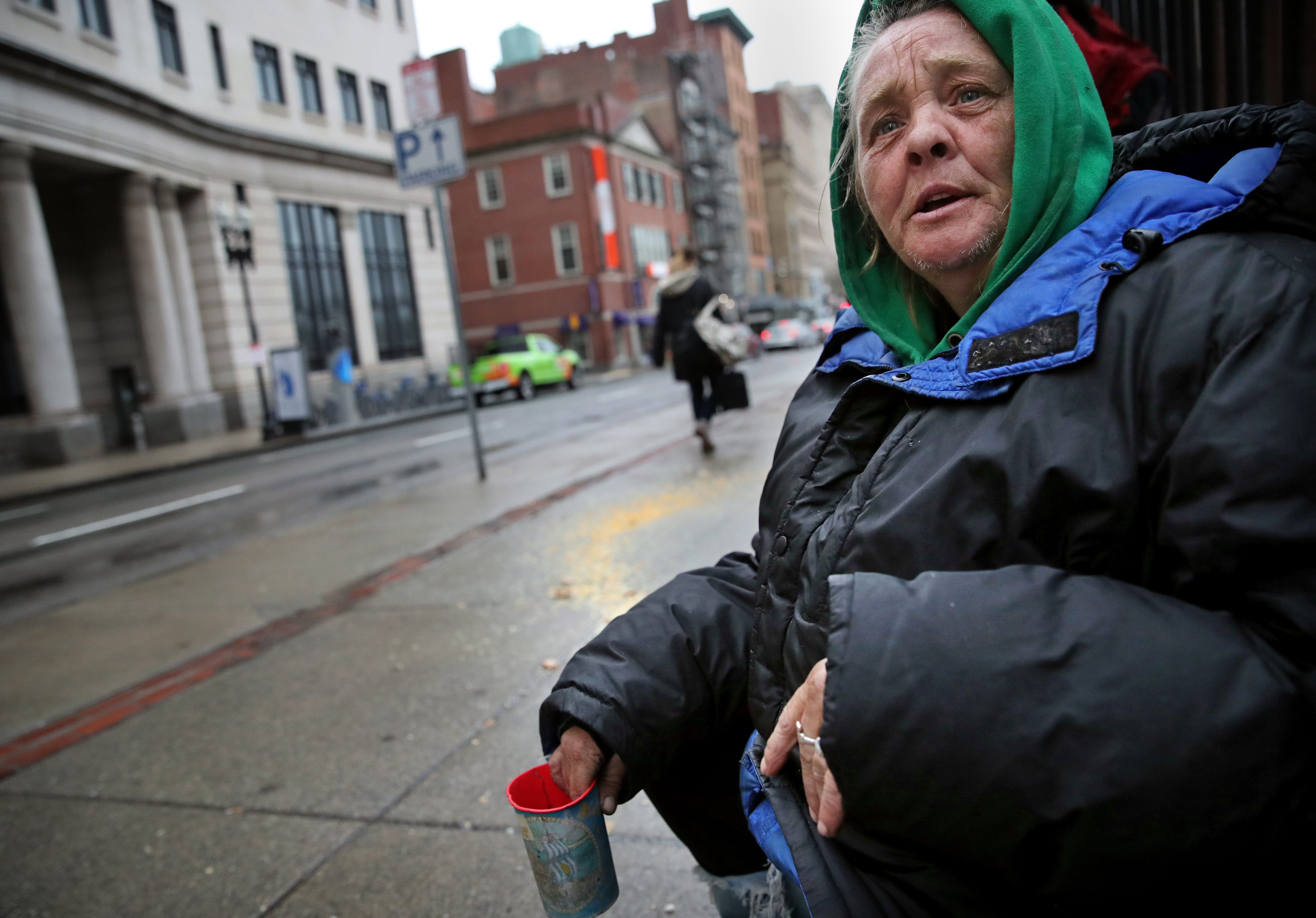 Brenda King panhandles for change on Tremont Street near the Park Street Church in Boston on Friday. "I'm going to ask my doctor for some masks," she said.