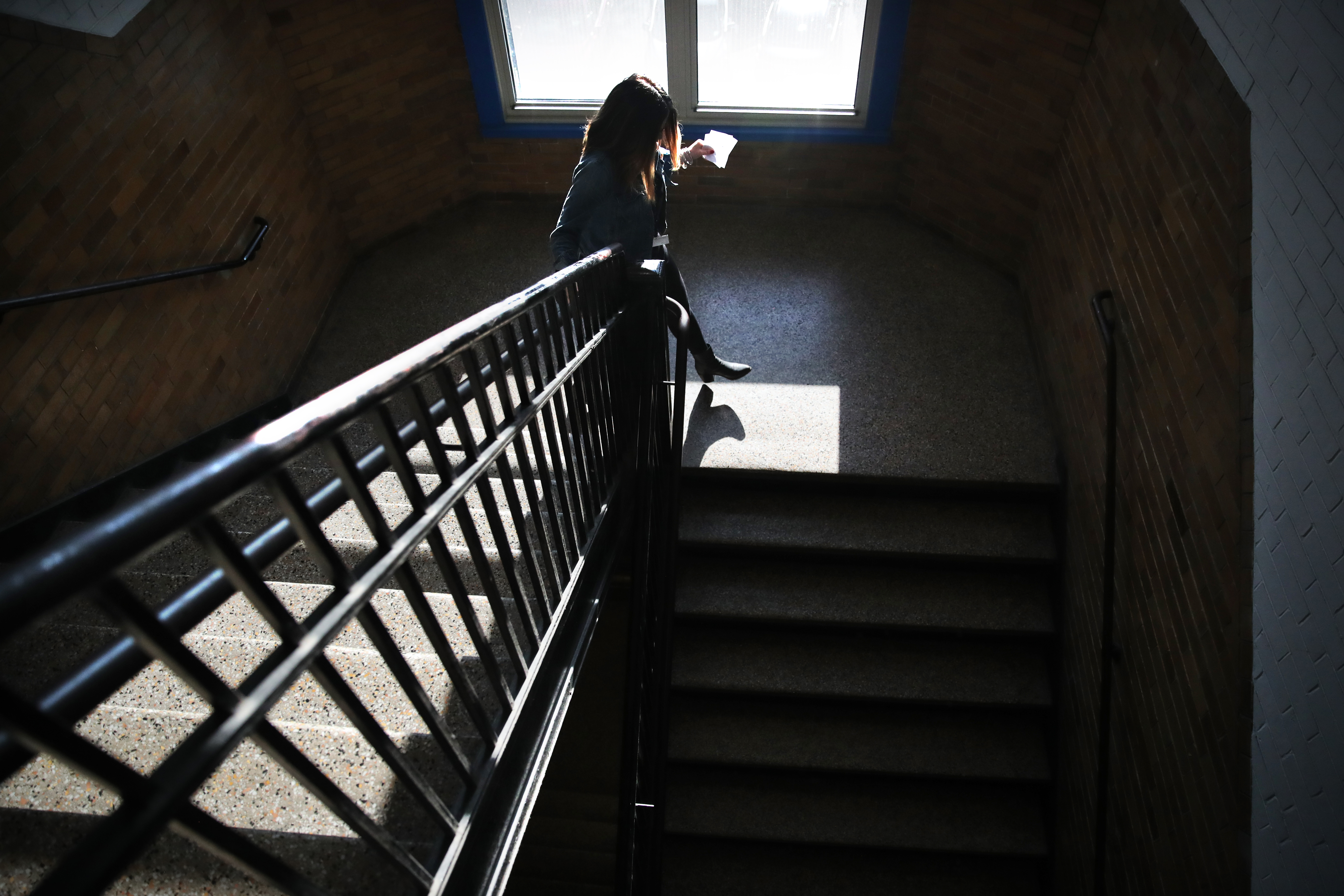 Guidance Counselor Jacquelyn Indrisano decended the stairs while delivering passes to students she has appointments scheduled with that day at East Boston High School.
