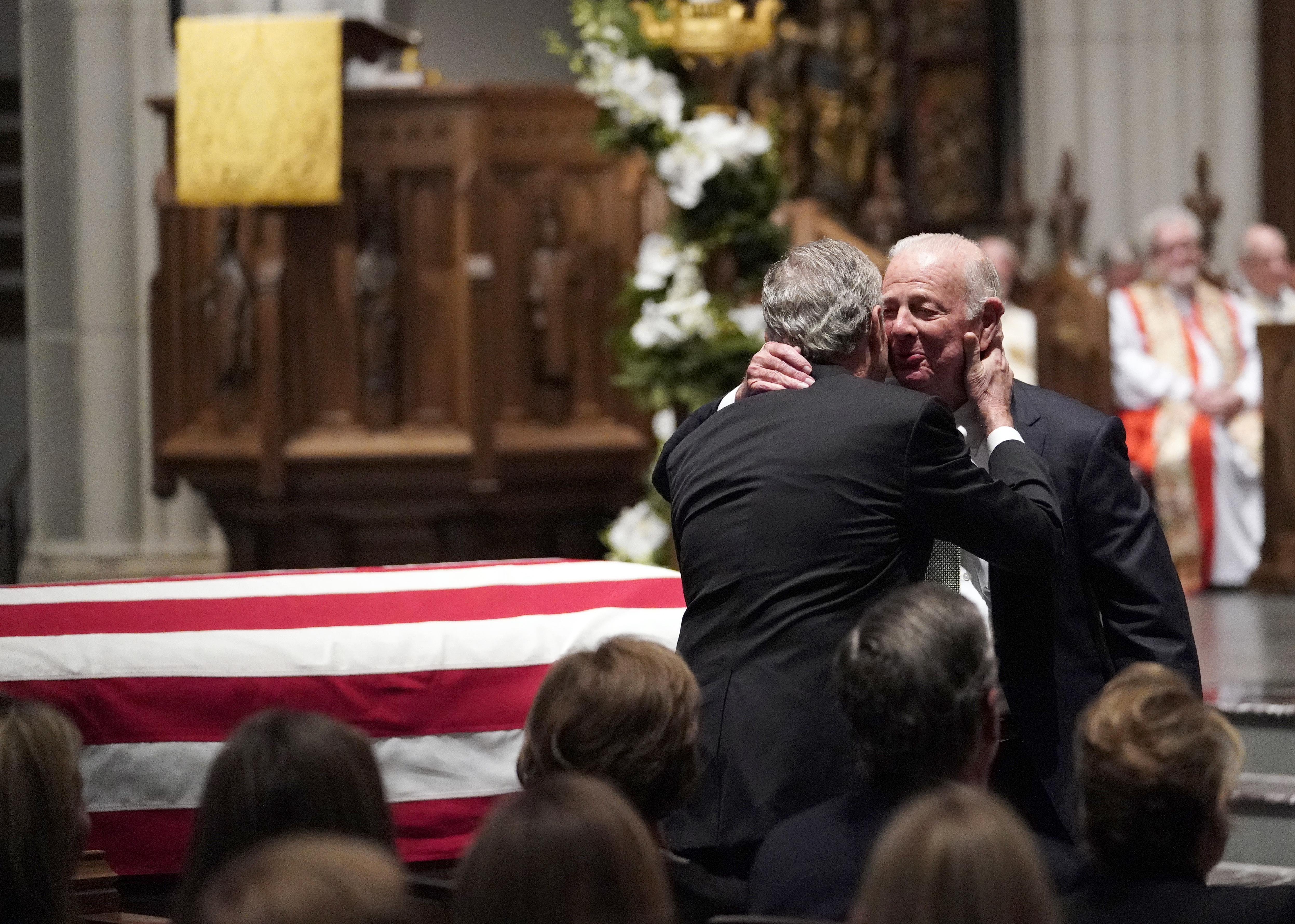 Former President George W. Bush embraced former Secretary of State James Baker (right) after he gave a eulogy .