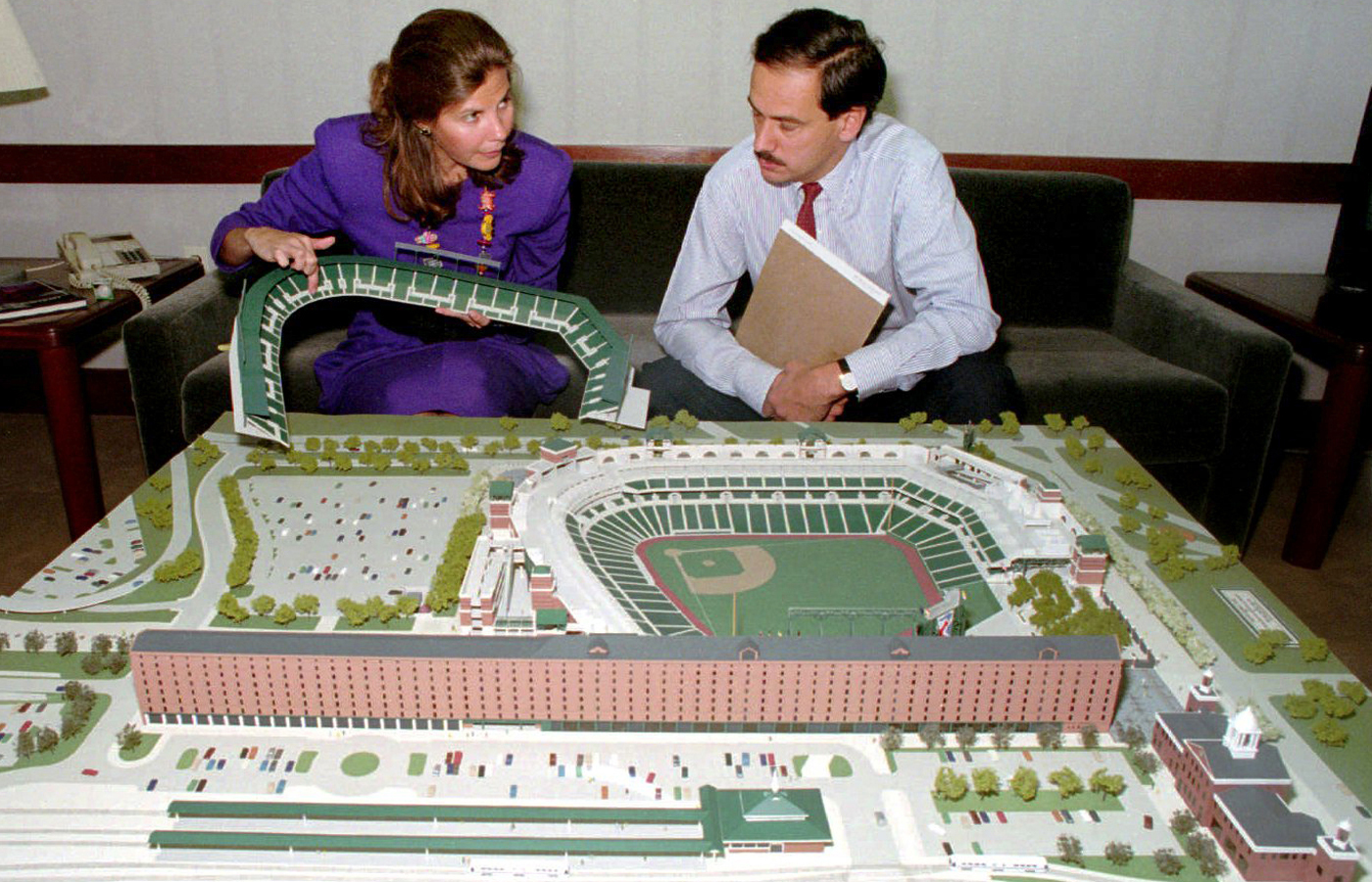 Janet Marie Smith and Larry Lucchino sit in front of a model of what would become Oriole Park at Camden Yards.