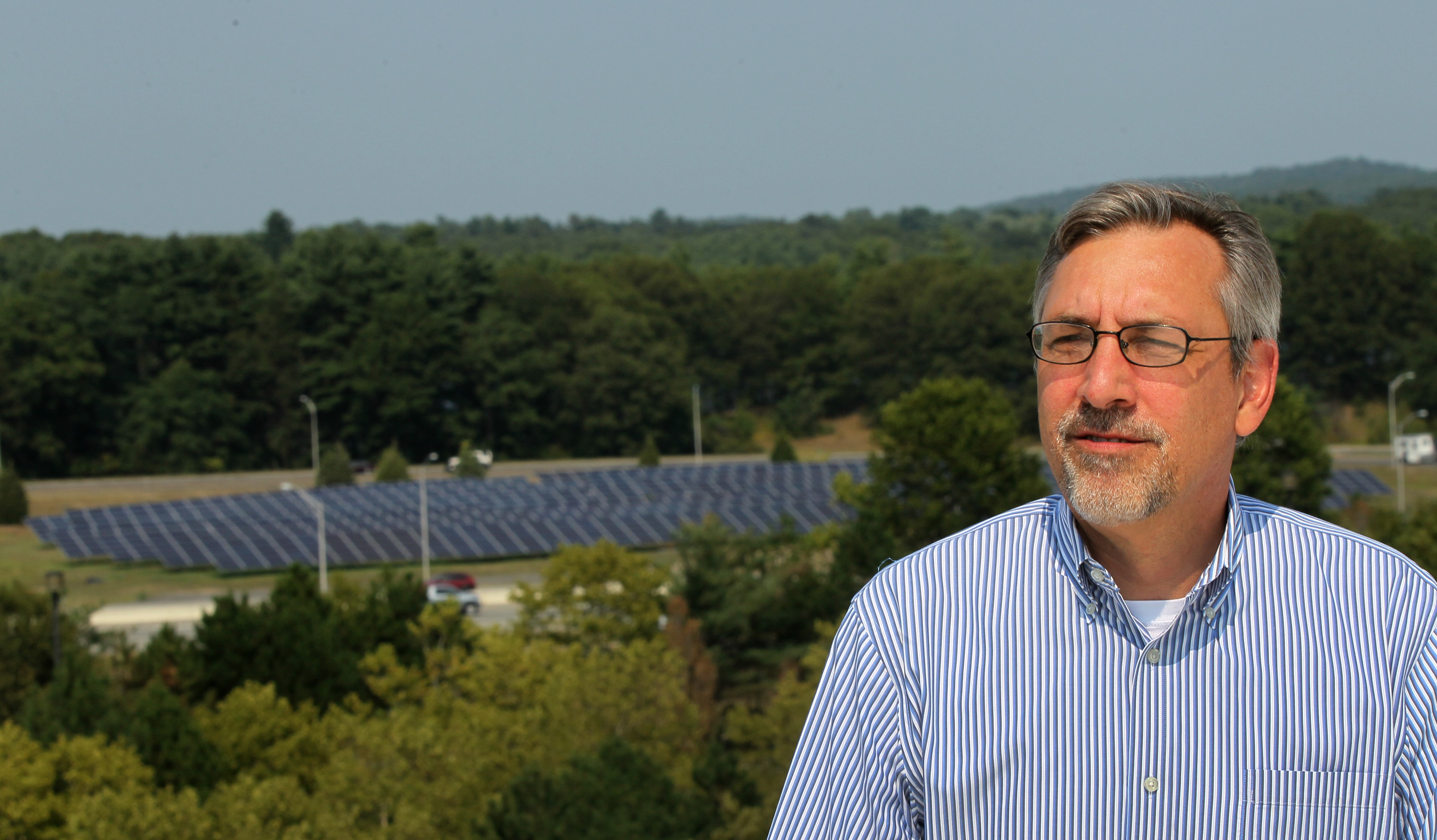 Joe DeManche, executive vice president at Ameresco, looked over one of the solar farms his company has built along the Mass. Pike in Framingham.