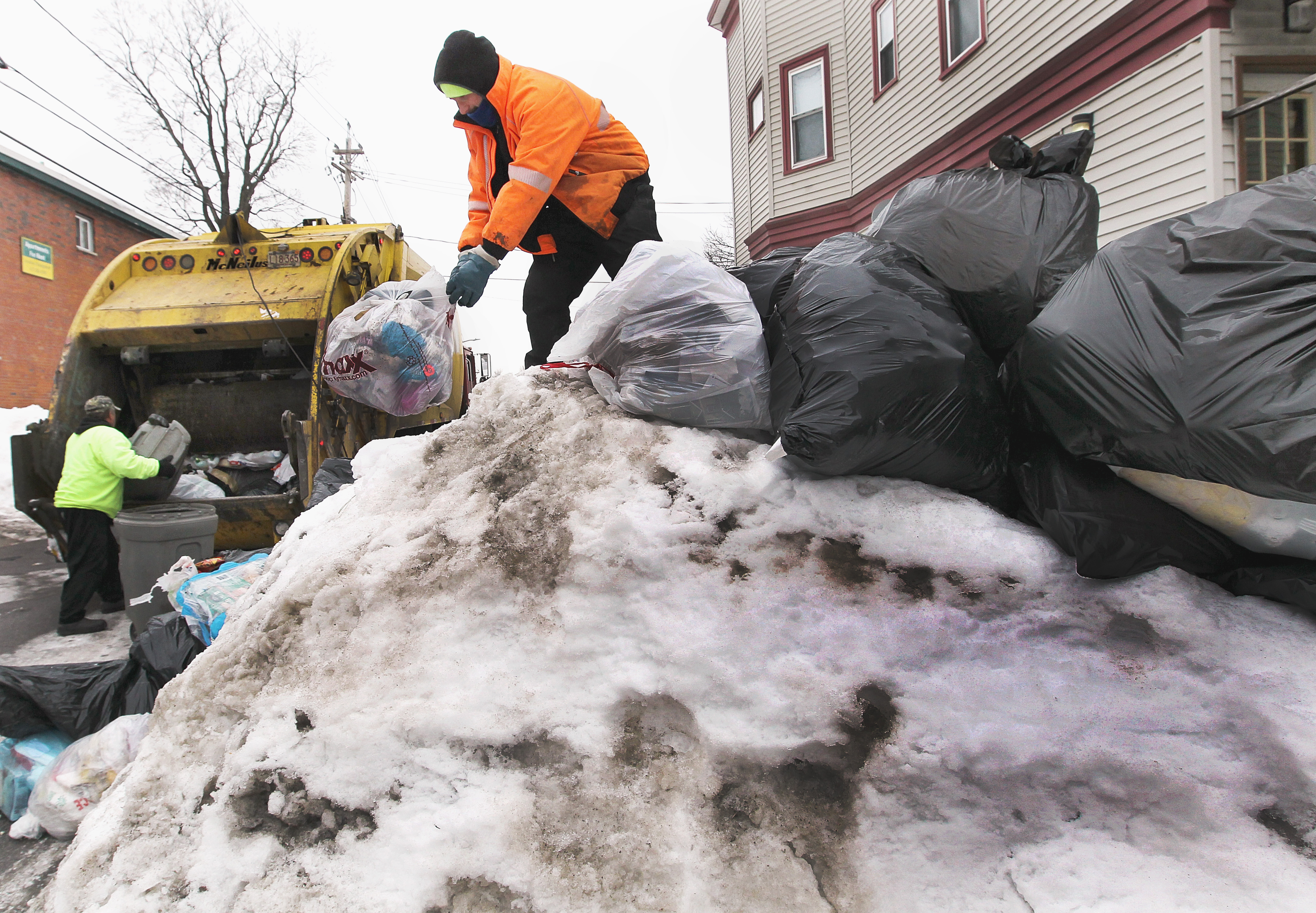Ralph De Pillo (left) and Altamiro Coutinh collected trash from snowbanks on Sumner Street in Dorchester.