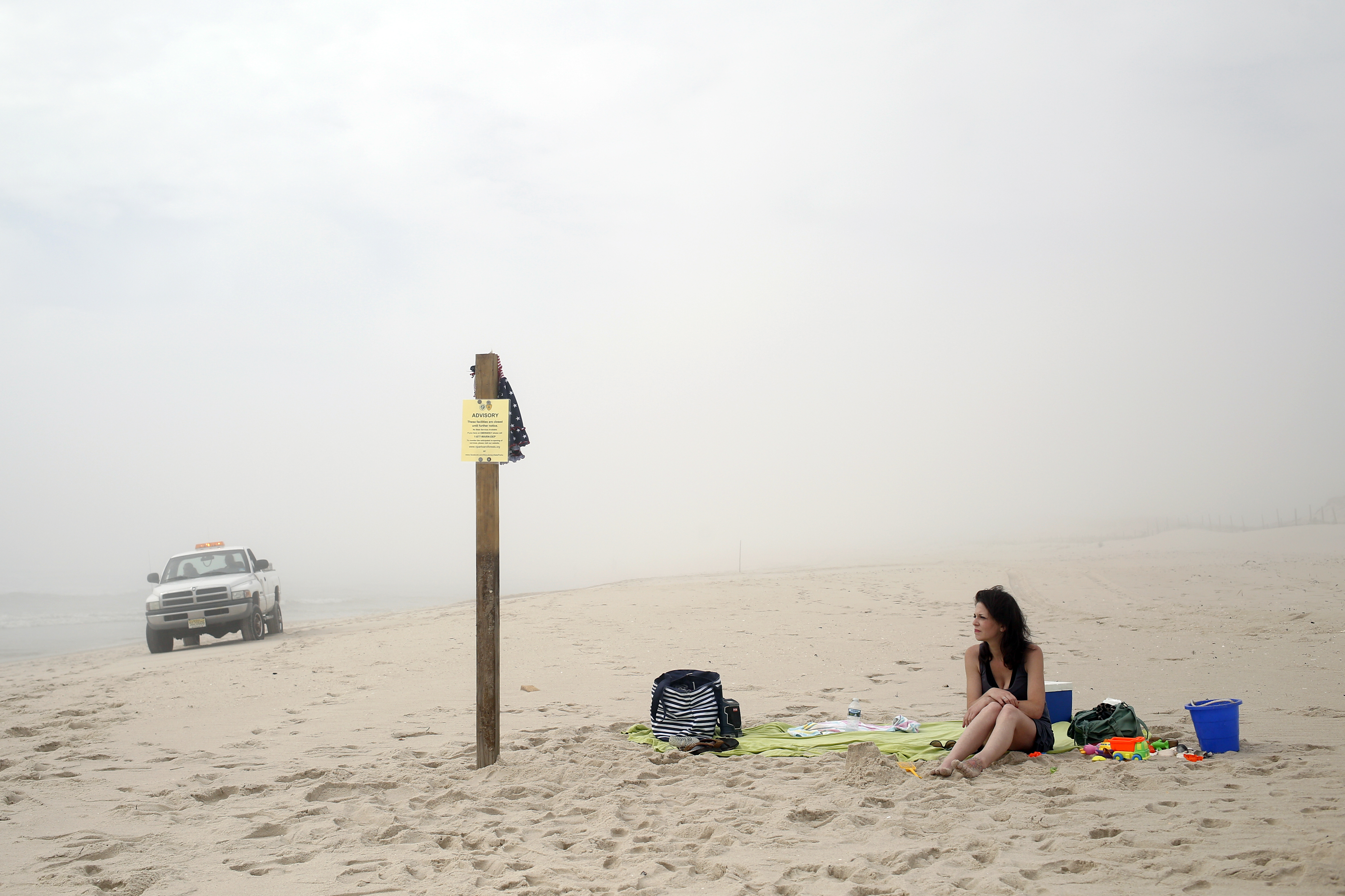 A woman sat on the border of Island Beach State Park as a park ranger patrolled the coastline on Saturday.