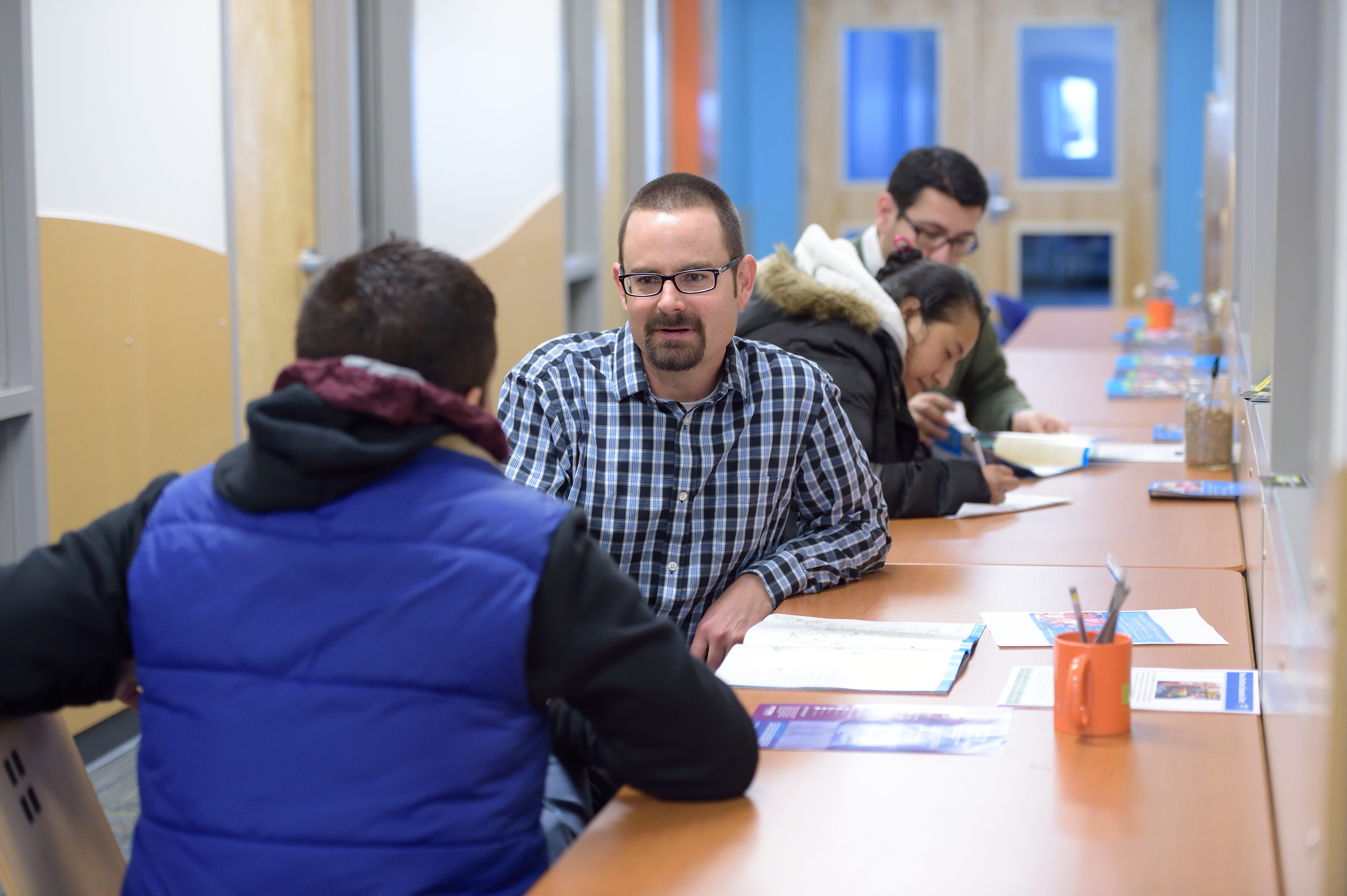 Denver schools enrollment representative Tim Tullar (center) spoke with a parent about enrollment options for his child.
