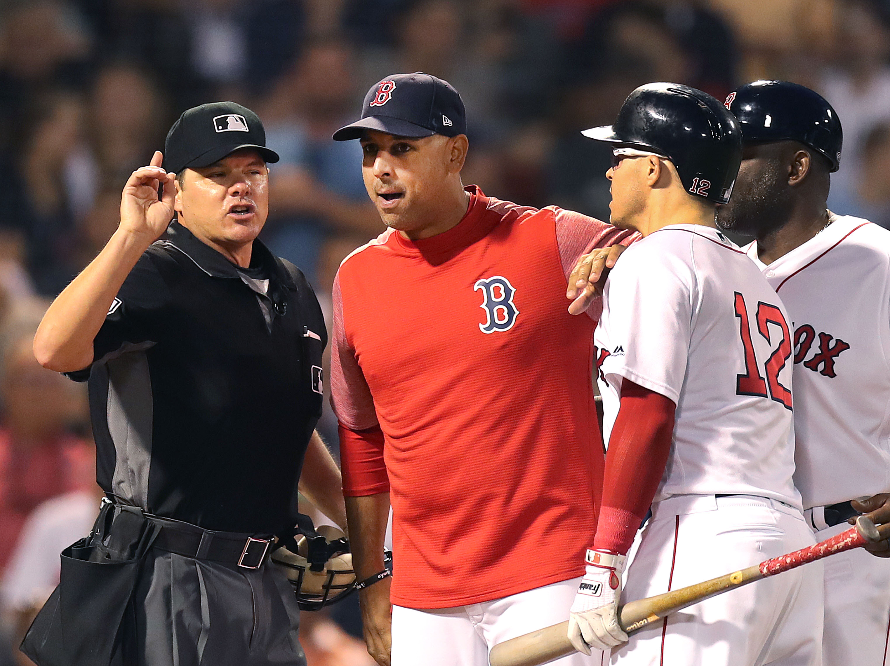 Manager Alex Cora argues as he holds Brock Holt back from home plate umpire D.J. Reyburn, who threw Holt out of the game in the third inning after Holt argued a called third strike.