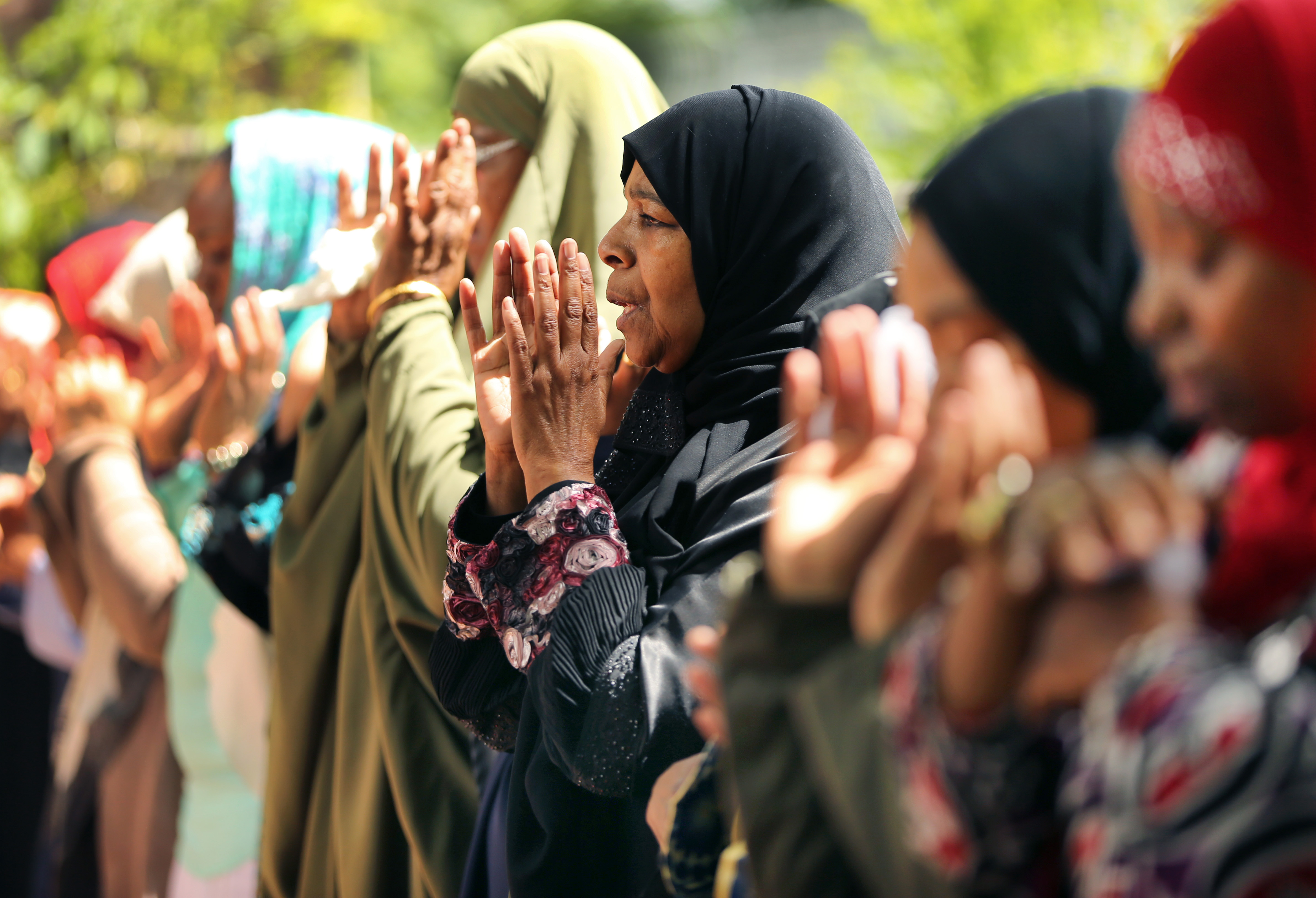 Rahimah Rahim (center) prayed during the funeral service for her son Usaama Rahim at the Mosque for the Praising of Allah.