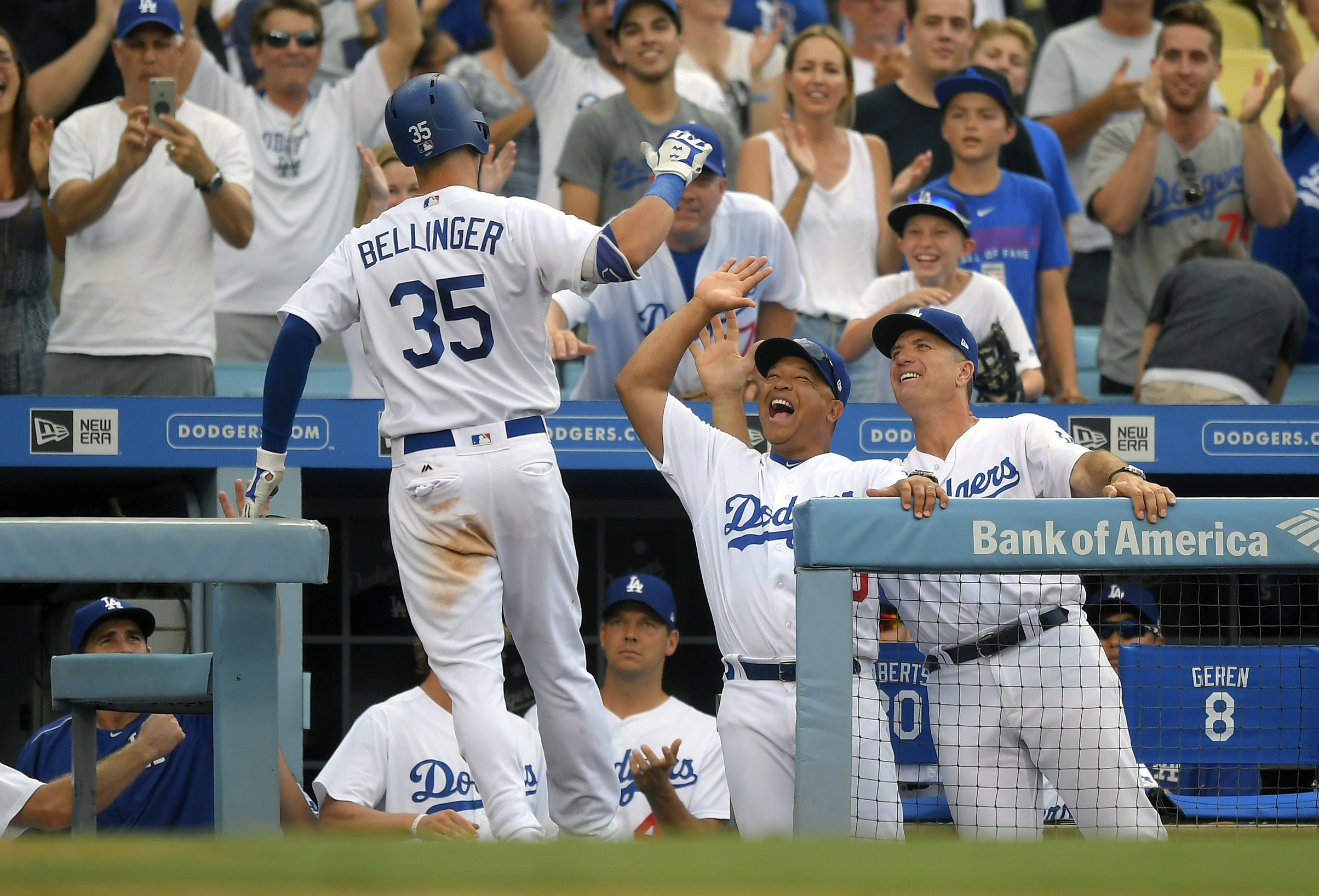 Dave Roberts goes to high five Cody Bellinger after a solo home run against the Royals in early July.