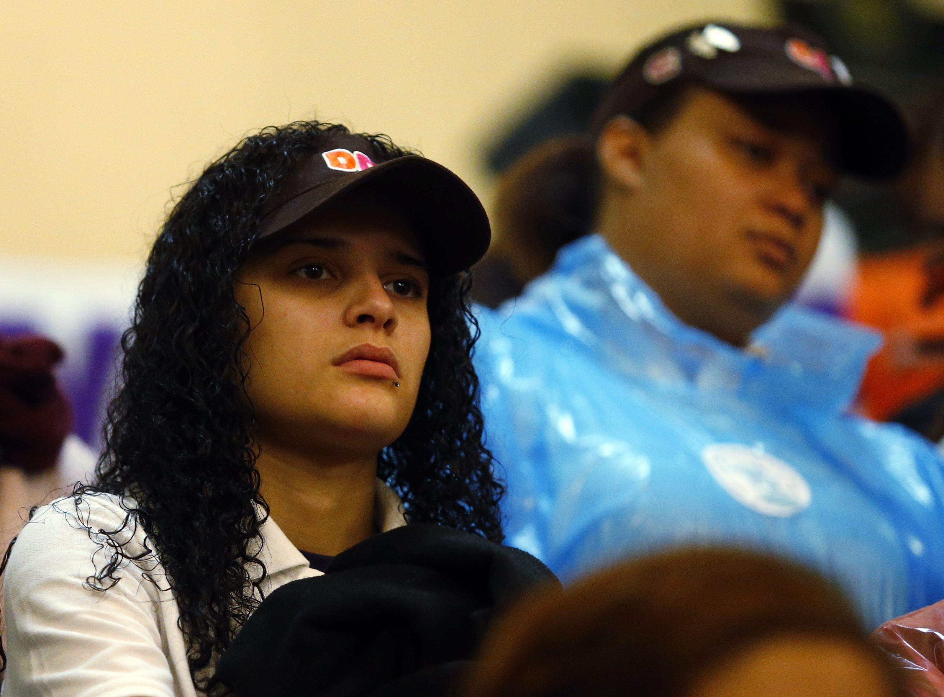 A woman wearing a Dunkin’ Donuts visor joined the crowd of protesters during the rally and march. One Dunkin’ employee said a pay bump would bolster her savings.