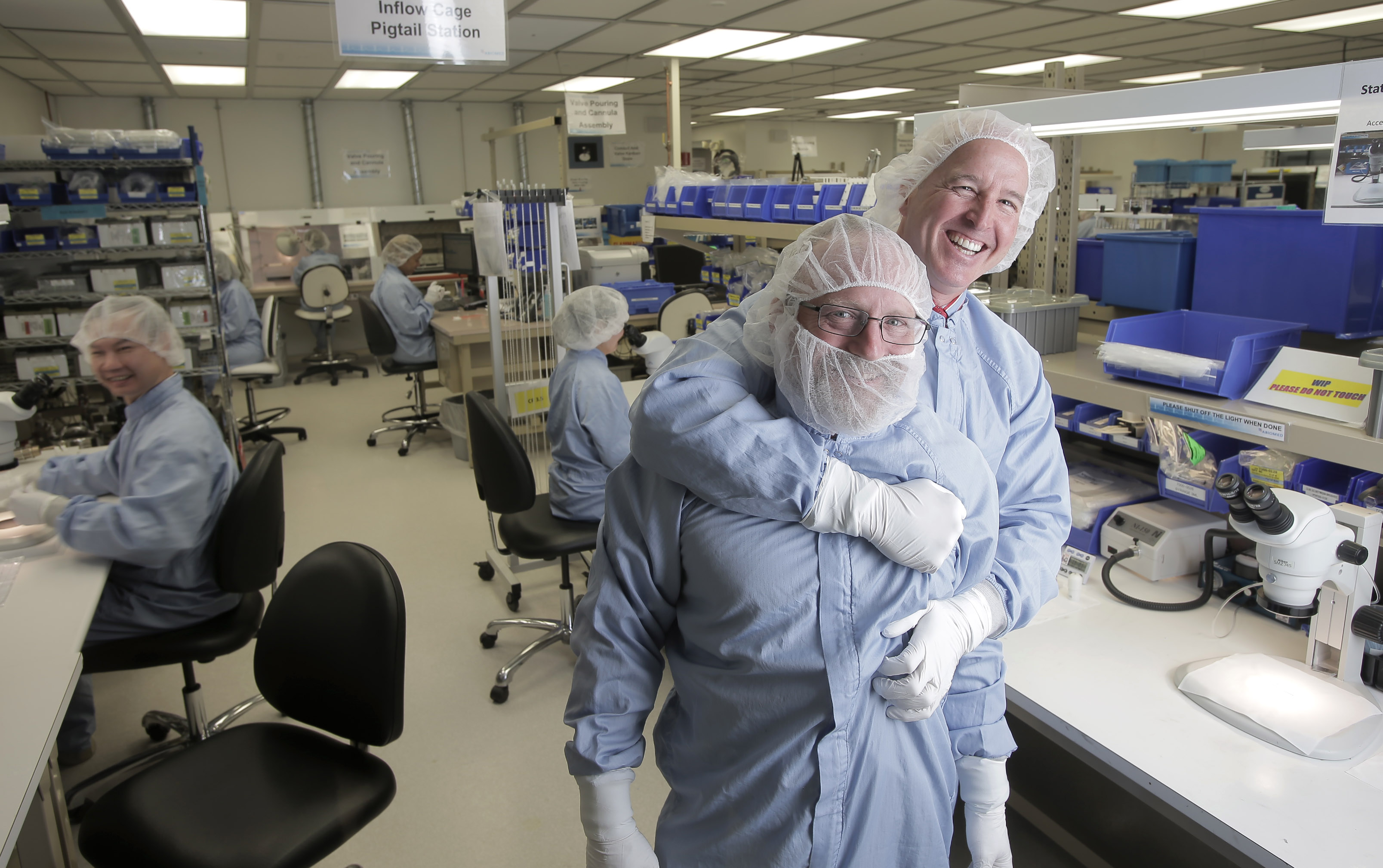 Abiomed leader Michael R. Minogue (rear) shares a light moment with production manager Vernon Rothrock in the company’s Danvers plant.