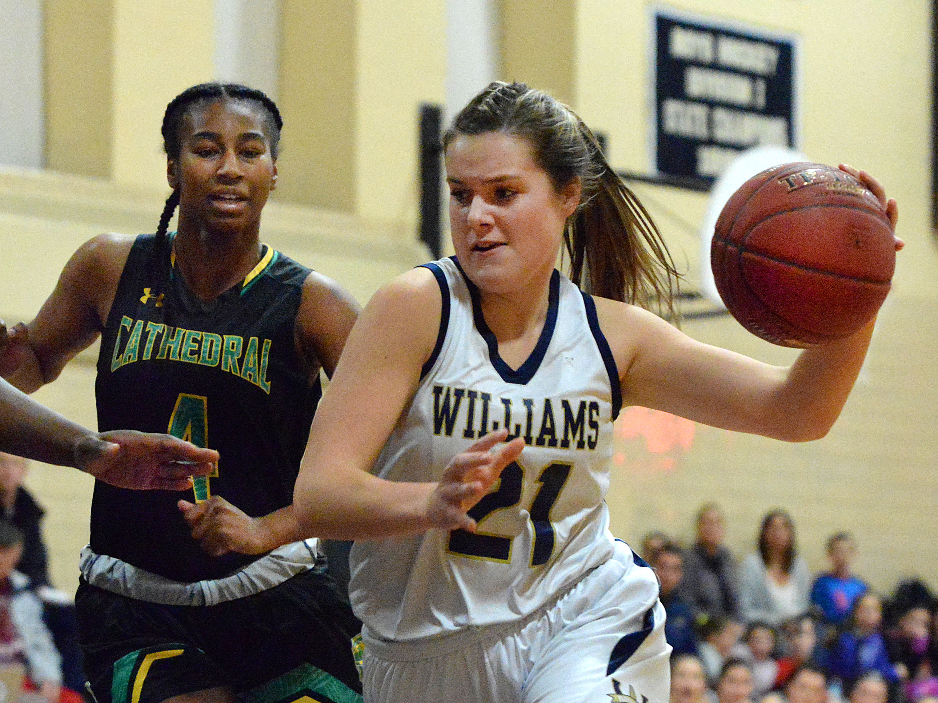 Archbishop Williams’s Monica Spain drives to the basket in the first half as Cathedral's Taliyah Countrymon looks on Friday night.
