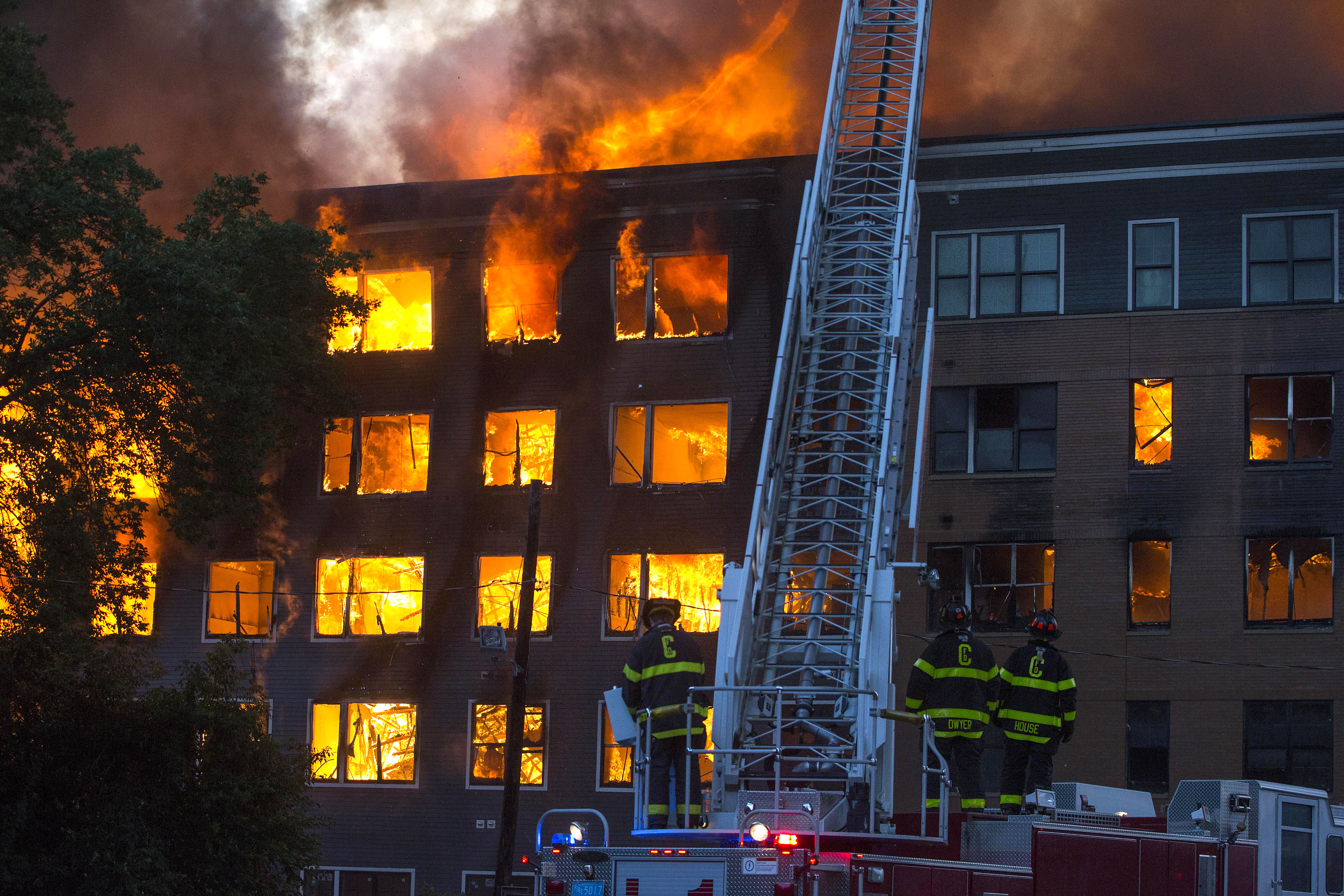 Cambridge firefighters watched as fire and smoke poured from a building.