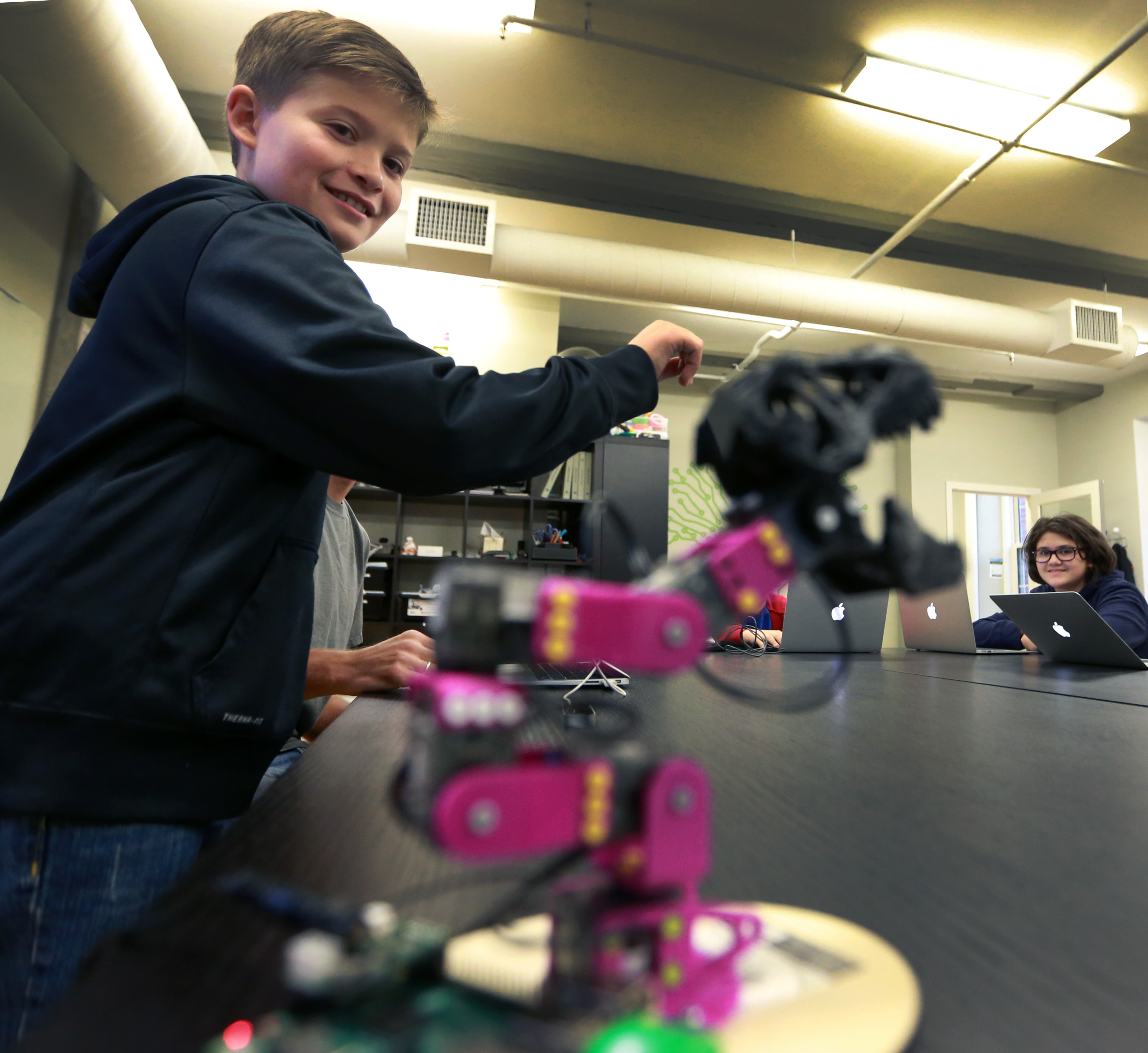 Brendan Ballon, 11, of Amesbury, tries out a robot that mimics his hand motions.