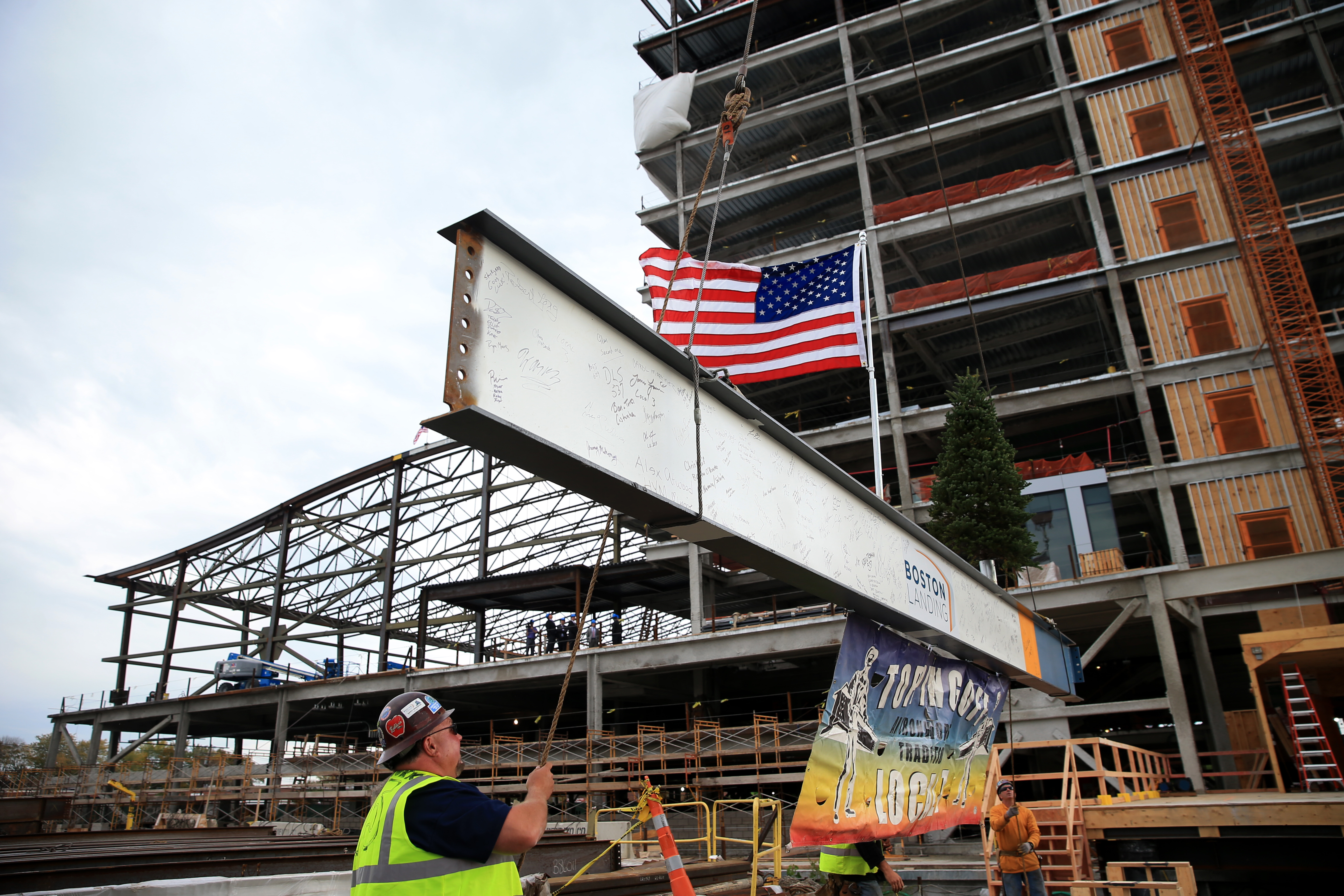 Jack Glavin, site forman for Prime Steel, helped guide a steel beam the topping-off ceremony at the new Warrior Ice Arena at Boston Landing.