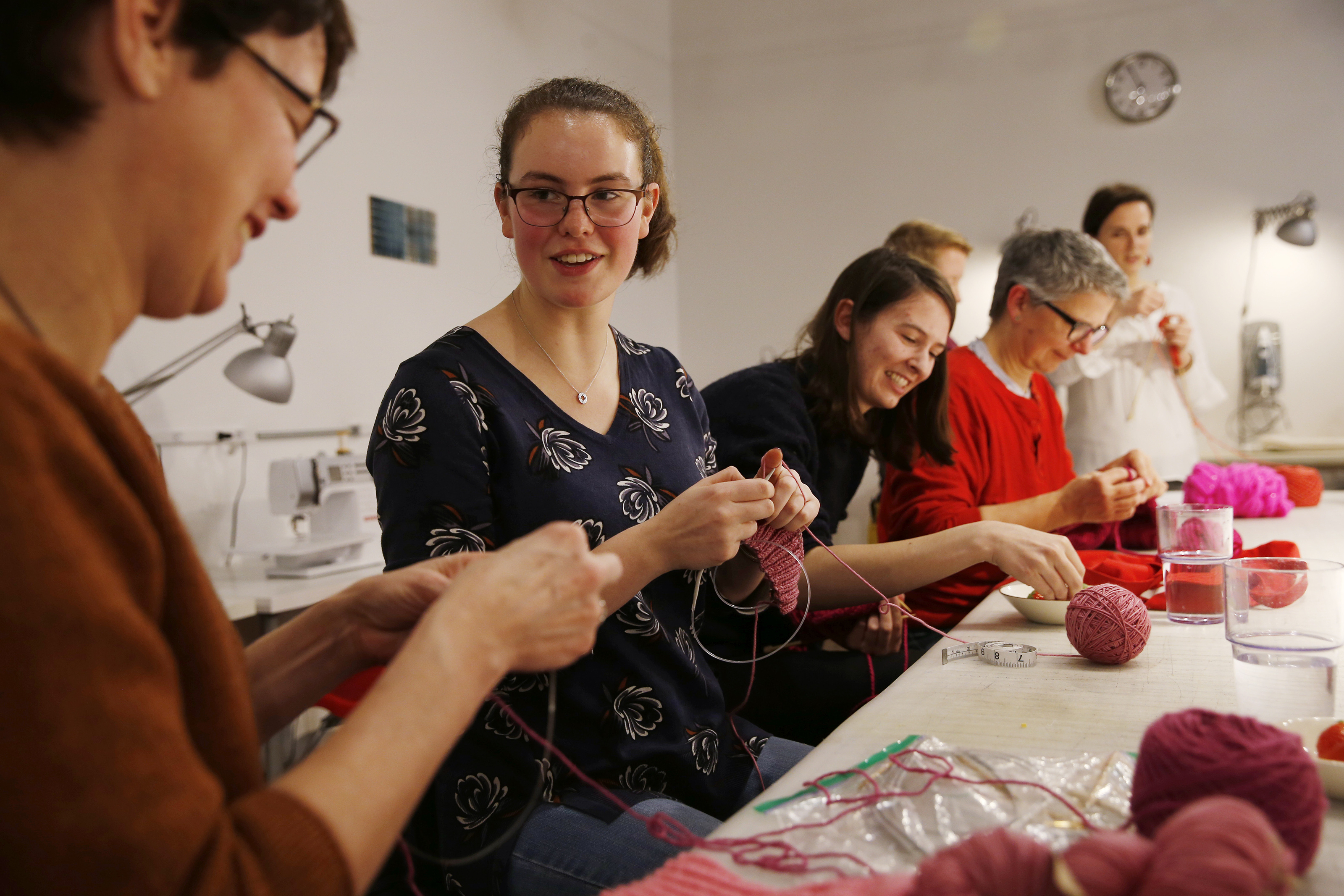 Lestra Litchfield of Cambridge (left) joked with her daughter, Lestra Atlas, as they and others knitted hats last week at Gather Here in Cambridge’s Inman Square.