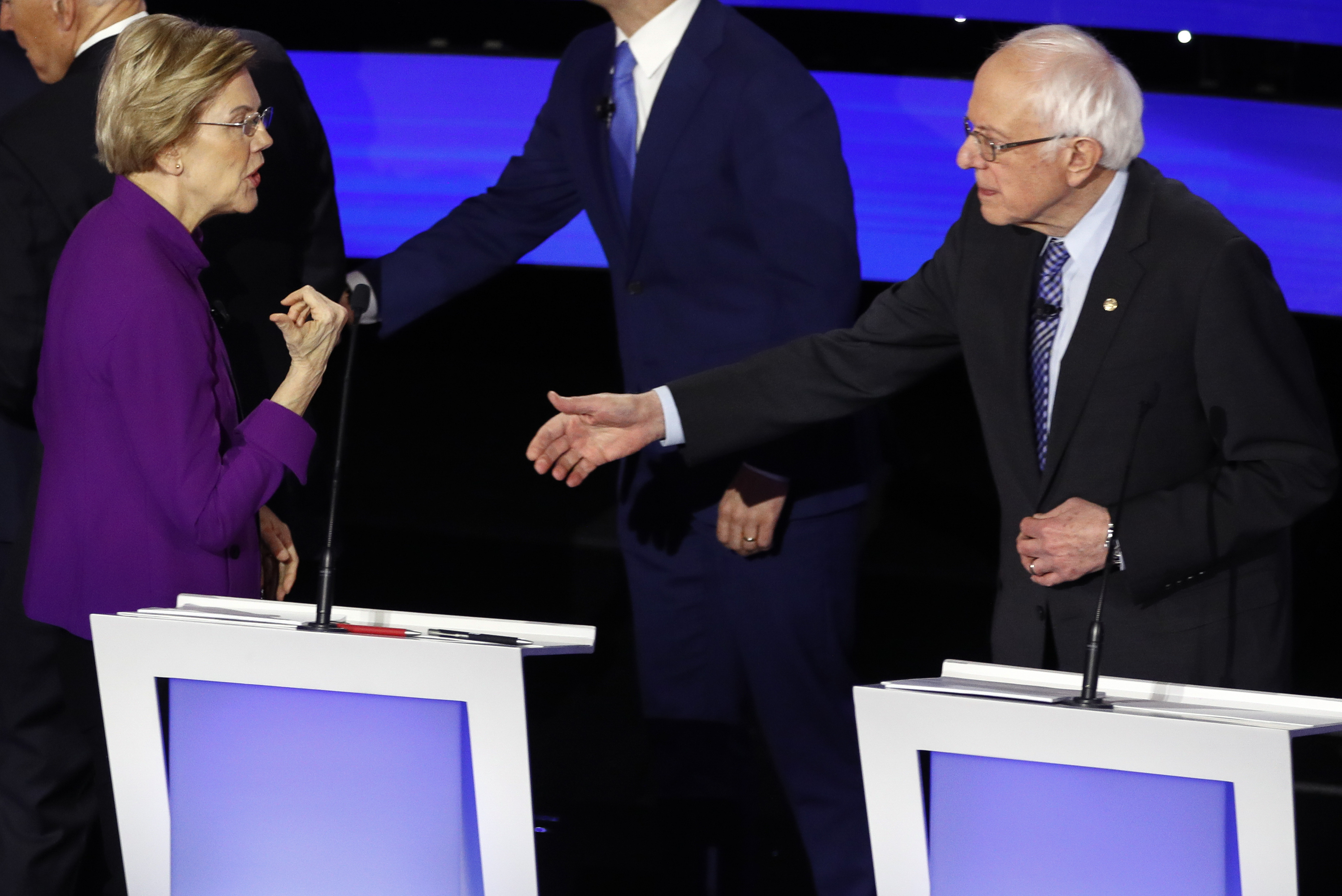 Senators Elizabeth Warren and Bernie Sanders interacted after the Democratic debate Tuesday night.