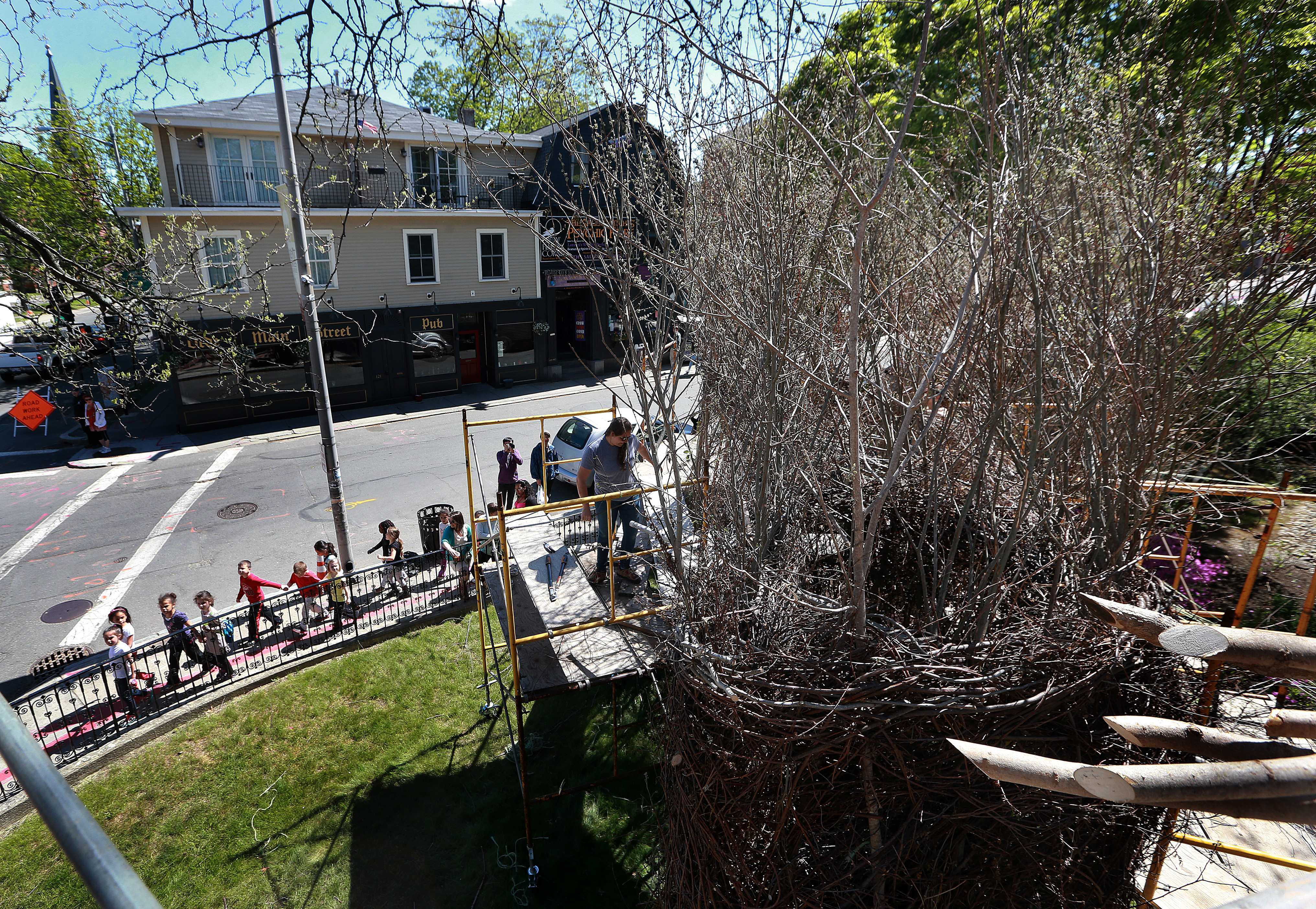 A group of children looked up at the sculpture “Stickwork” as they walked along the sidewalk.