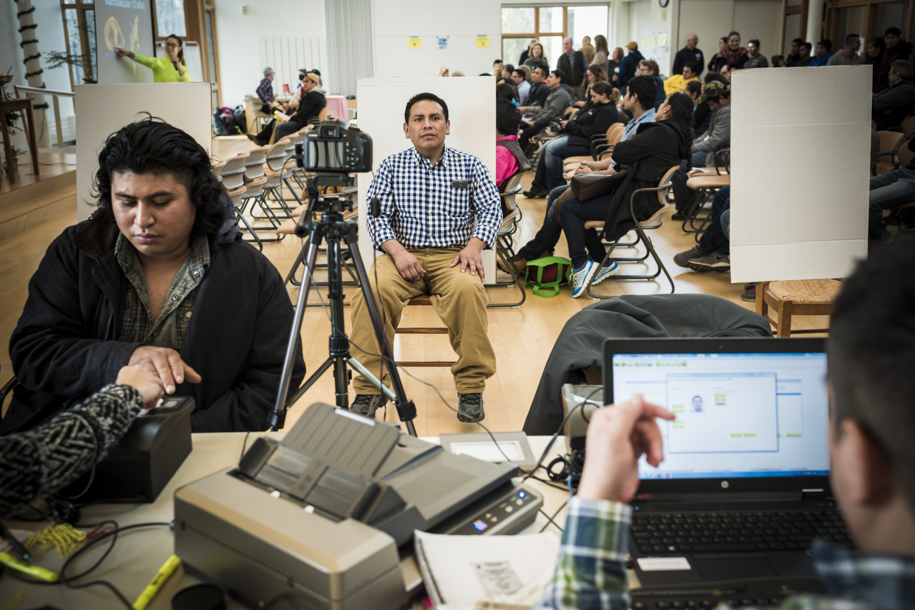 A migrant dairy farm worker prepared to get his passport photo taken by mobile operation run by the Mexican consulate, at the Champlain Valley Unitarian Universalist Society in Middlebury, Vt.