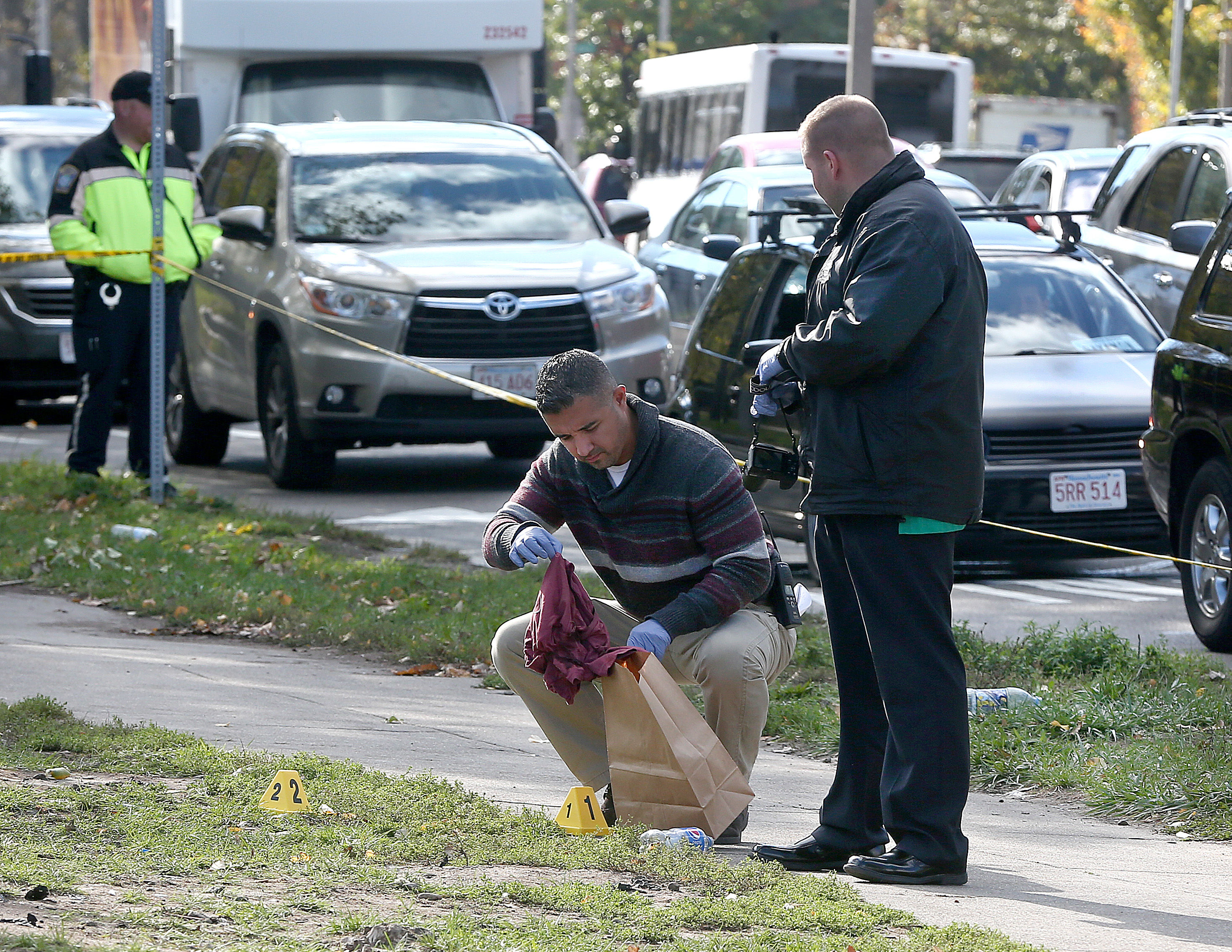 A Boston police detective placed a red shirt in an evidence bag.