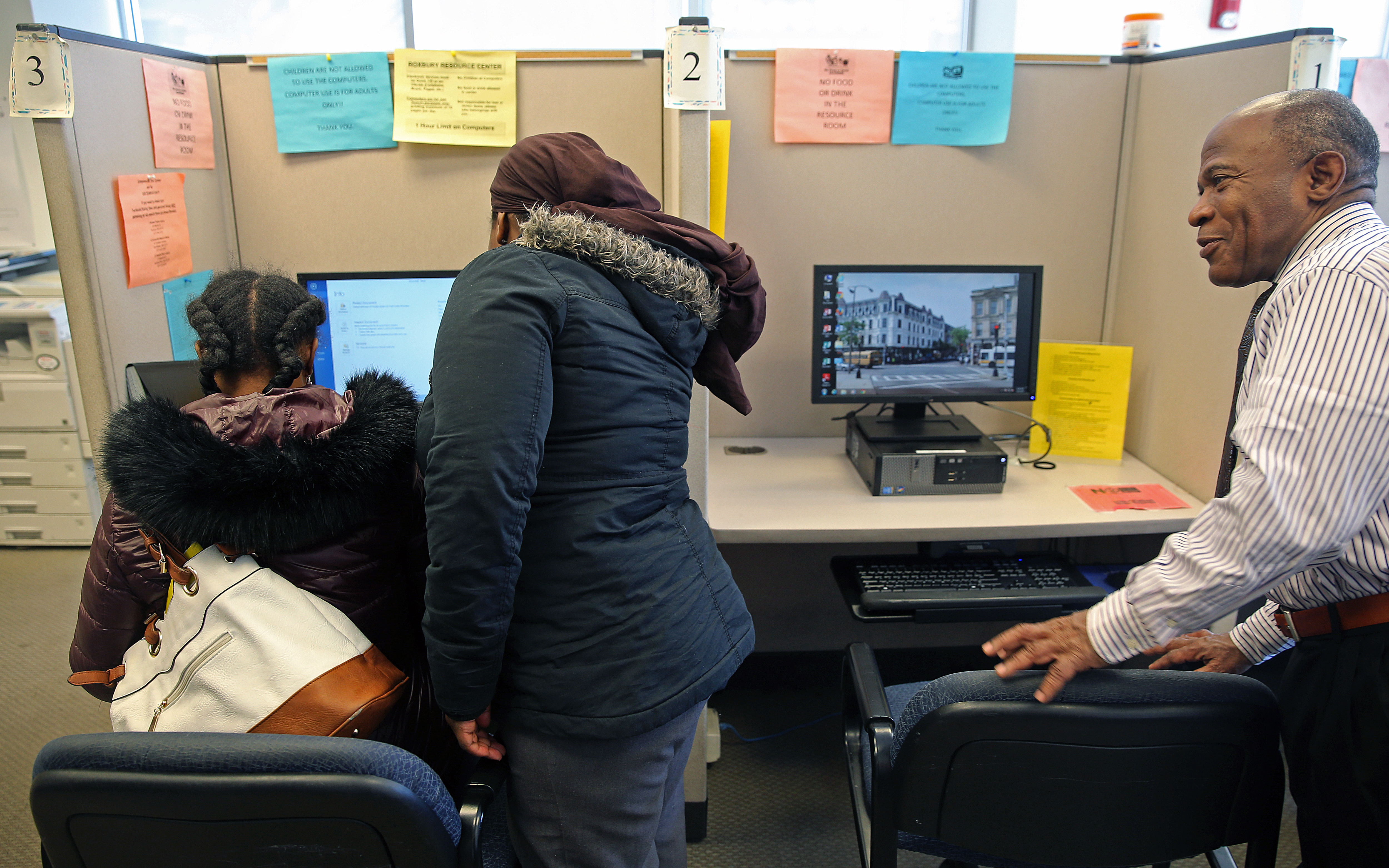 Alan Gentle (right) assisted clients at the Roxbury Center for Financial Empowerment.