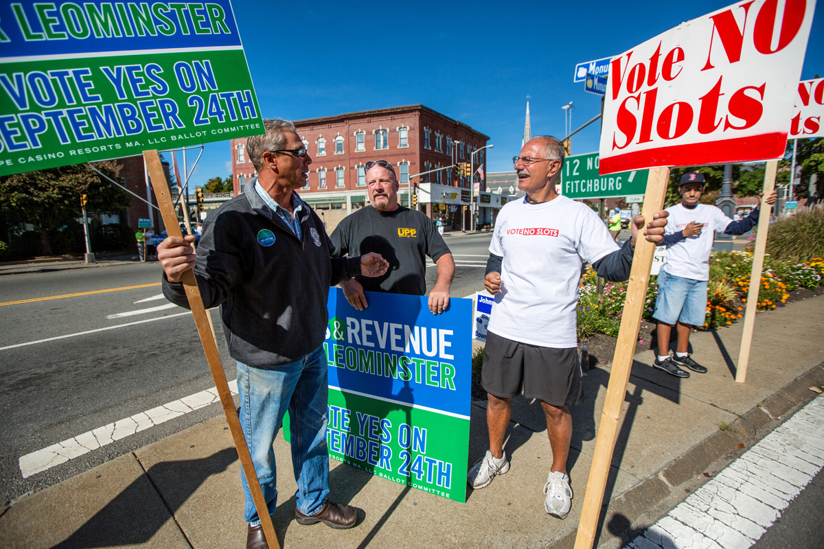 Residents vote Tuesday on David Cordish’s $200 million project, which, if approved, will compete for the state’s only slots license. At left, Rick LaBonte and Rich Brow, who favor the project, and casino opponent Joe Tammaro held signs in downtown Leominster Saturday to try to sway voters.