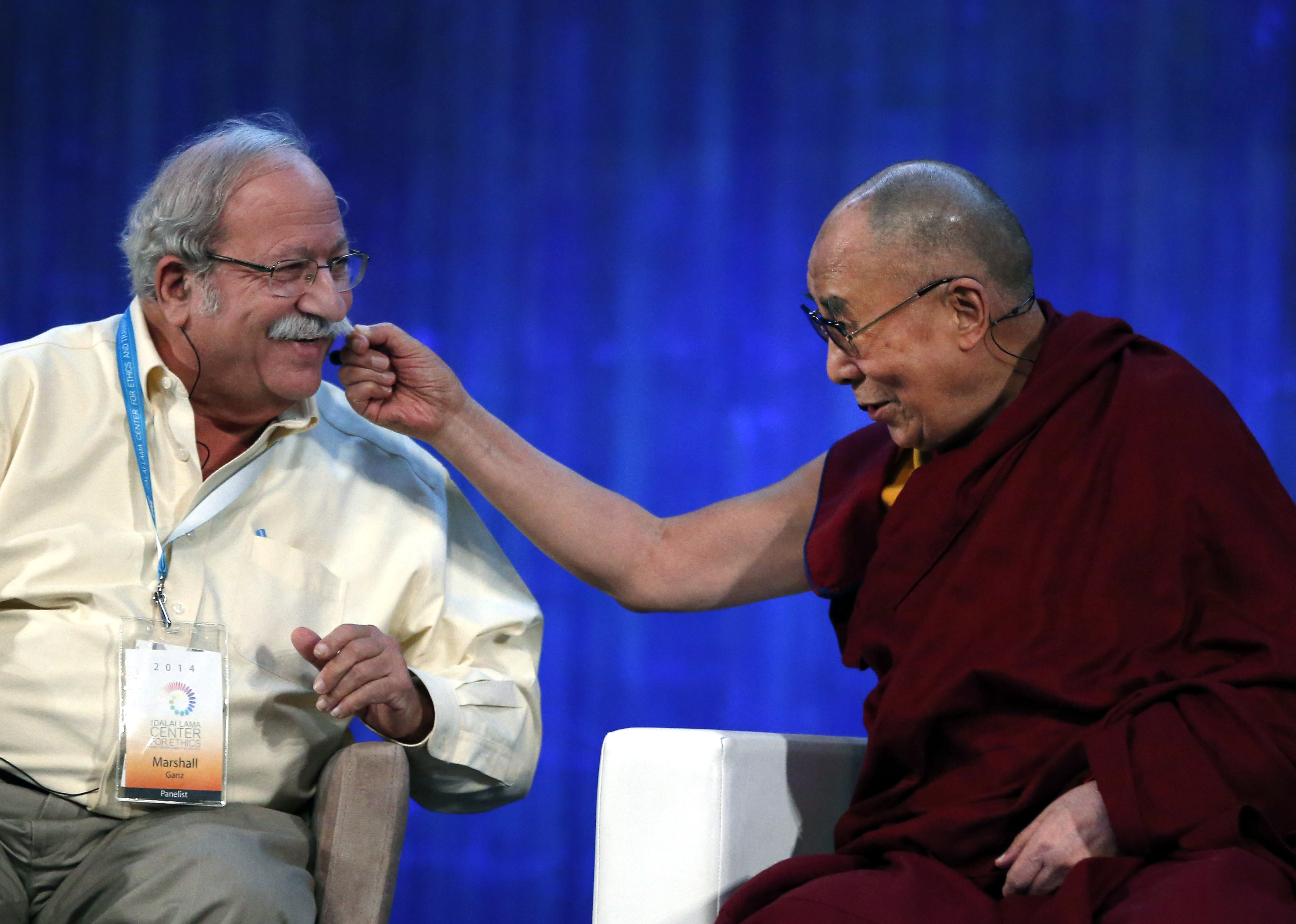 The Dalai Lama playfully pulls the mustache of Harvard's Kennedy School Professor Marshall Ganz during an appearance at the Massachusetts Institute of Technology in 2014.
