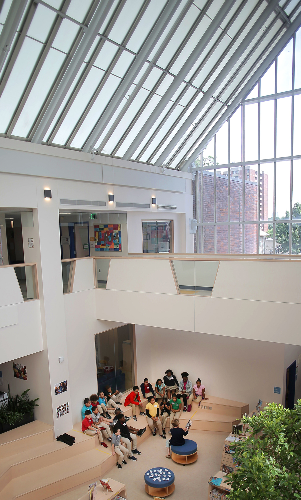 Students listened to a volunteer reading a book in the atrium library at Bridge Boston Charter School.