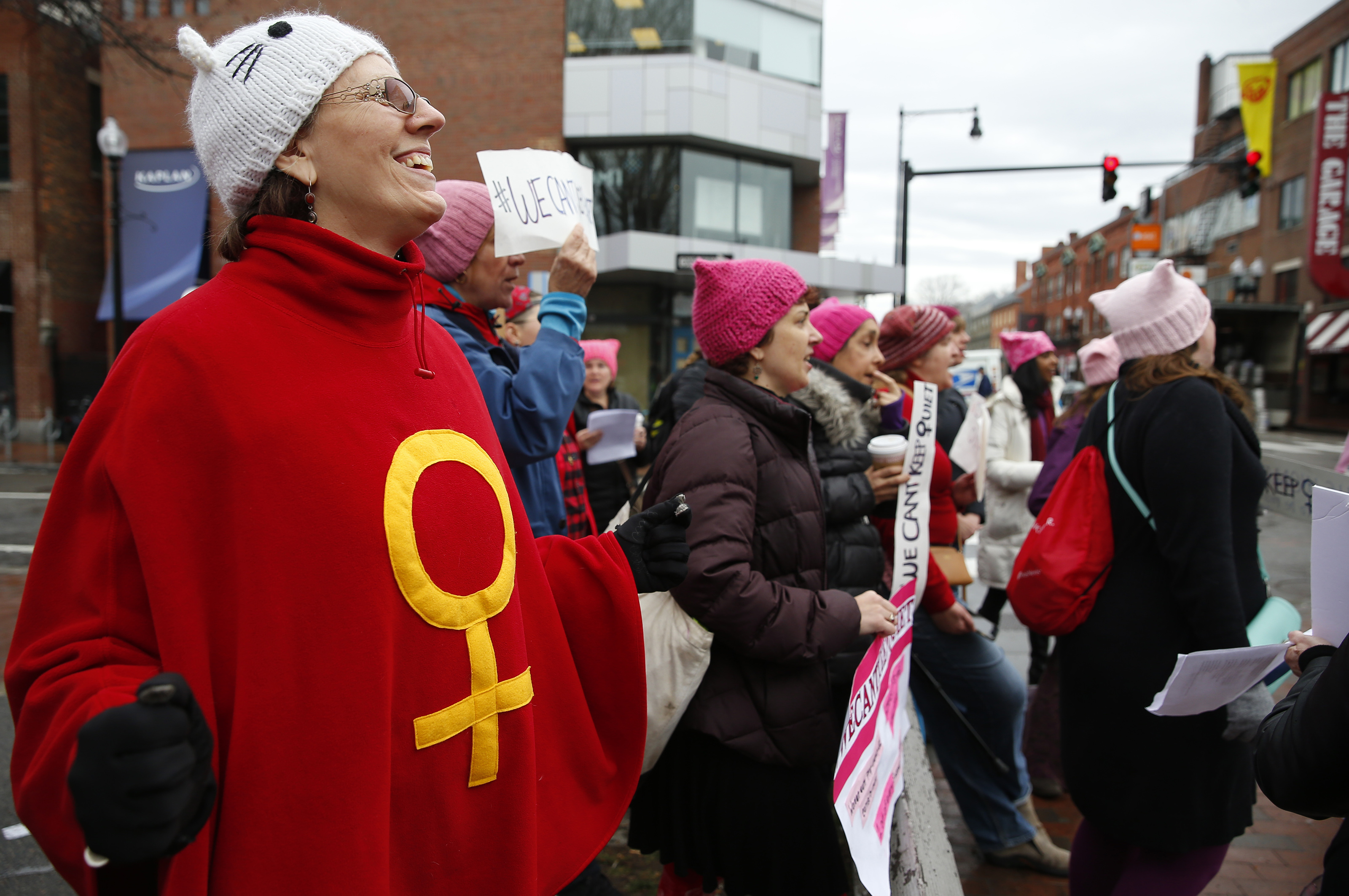 Teresa Tapper, 60, of Stoughton (left) sang along with other women gathered in Harvard Square.