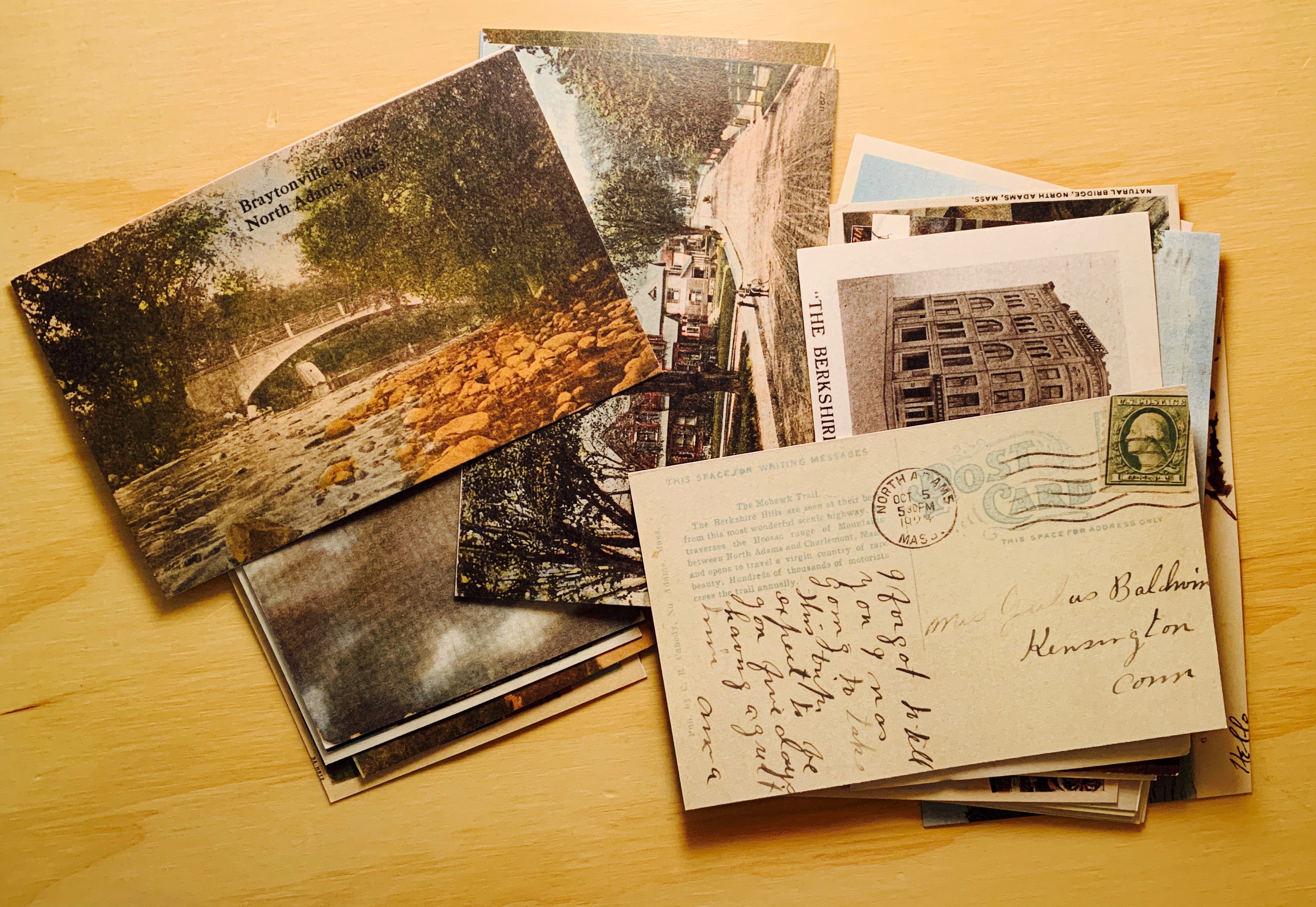 A stack of turn-of-the-last-century postcards sit in a room at Tourists.