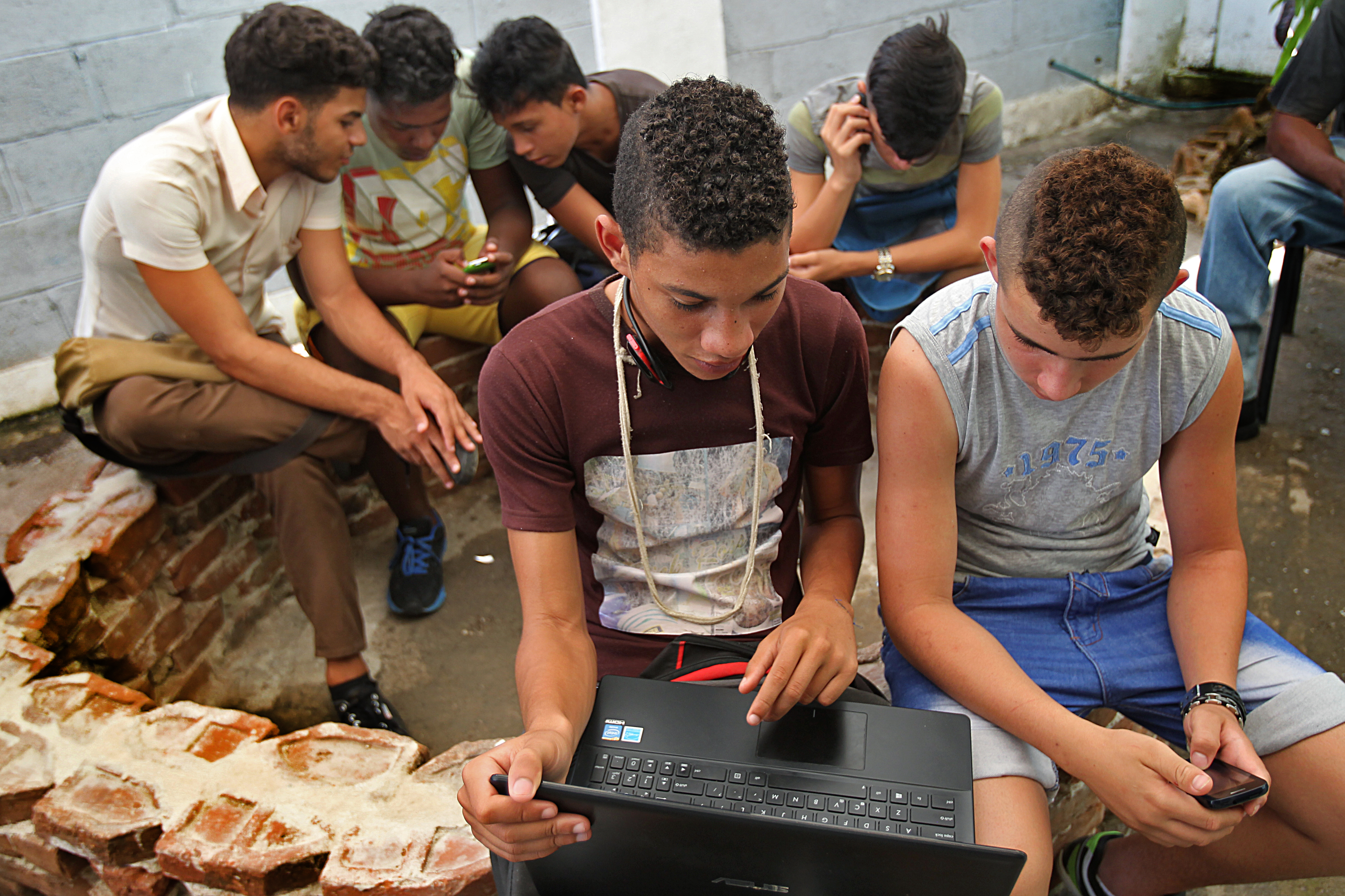 Young people access the internet under a hot tin roof at the Kcho Cultural Center.