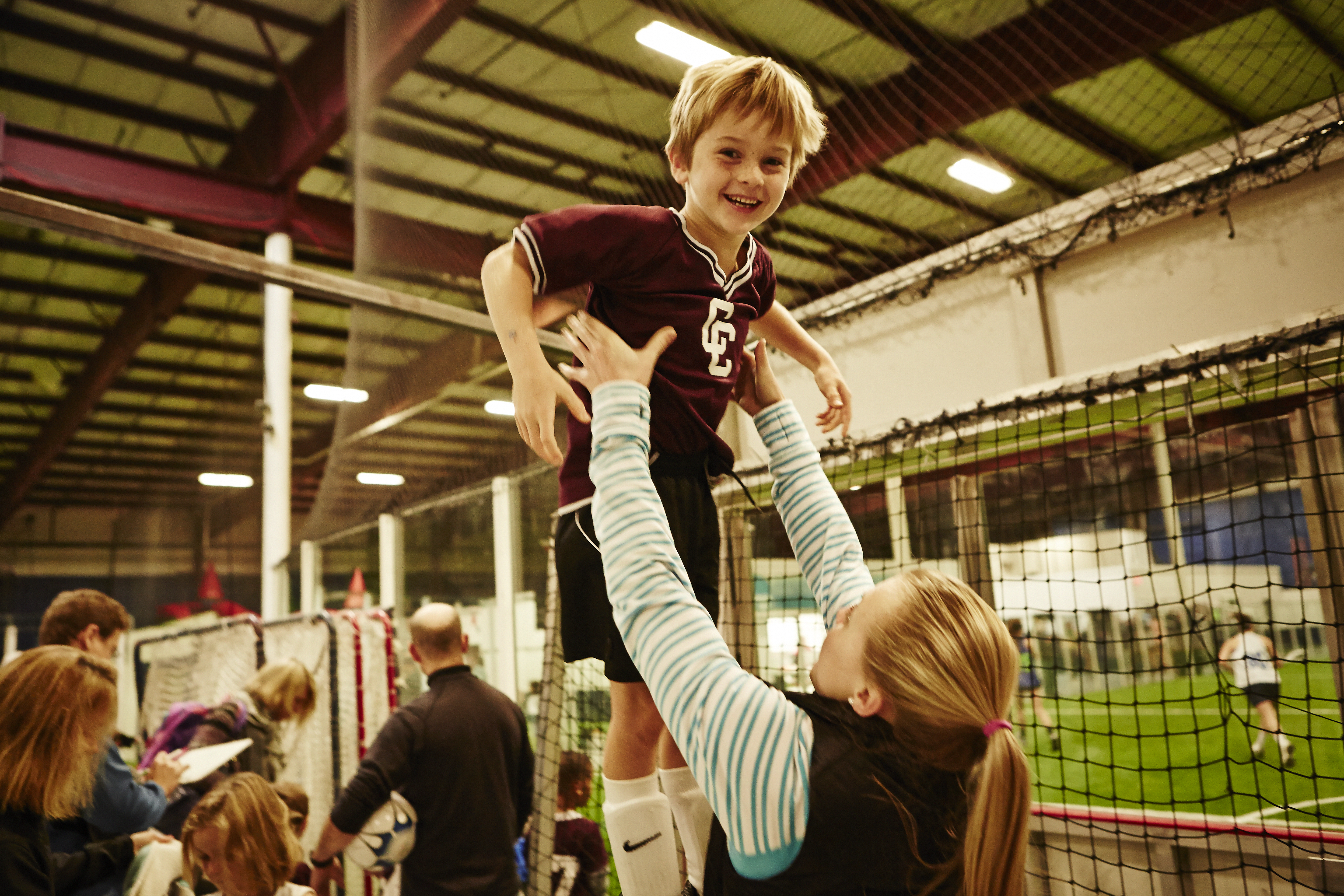Forward Kendall Coyne gets playful with Callen Beveridge, a member of her host family, before his youth soccer game.