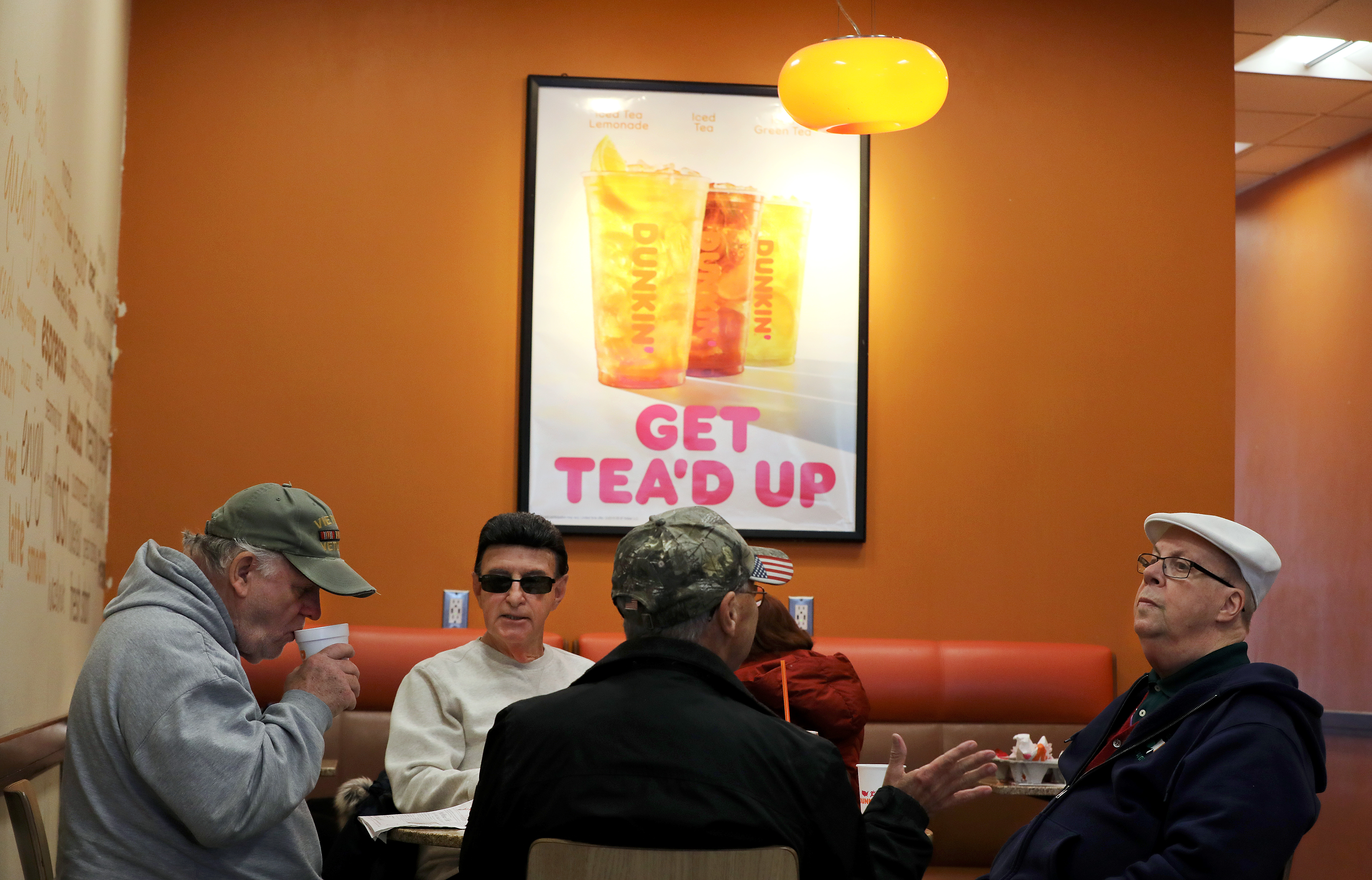 Joe Donovan (left), Michael D. Ambrosio (second from left), and Francis Wiemert (right) joined a friend at a Dunkin’ shop in Charlestown to drink beverages at a discounted rate. Seniors enjoy discounts on movie tickets, clothes, national park passes, and other goods.