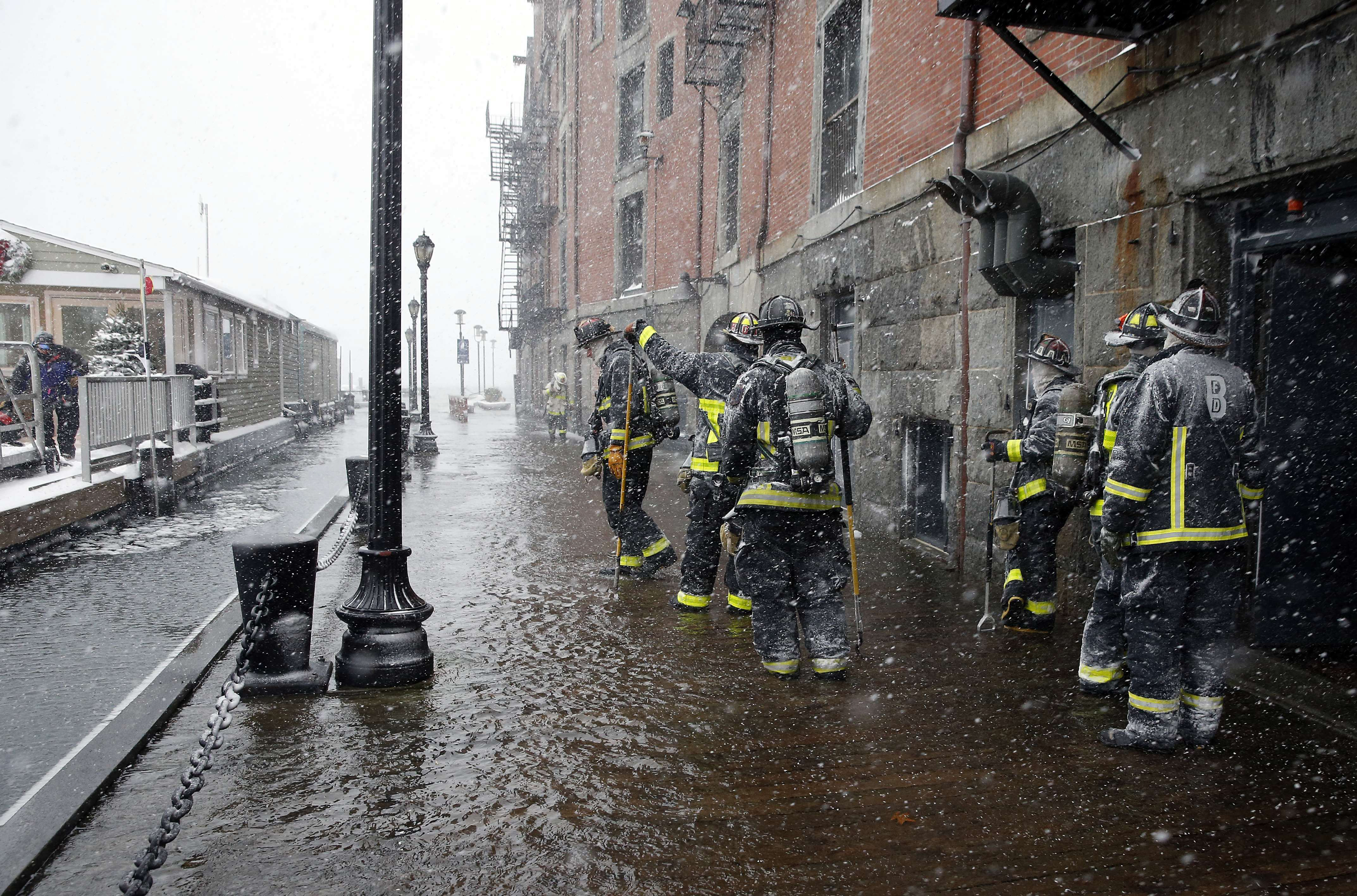 Boston firefighters worked at the scene of flooding from Boston Harbor on Long Wharf in Boston.